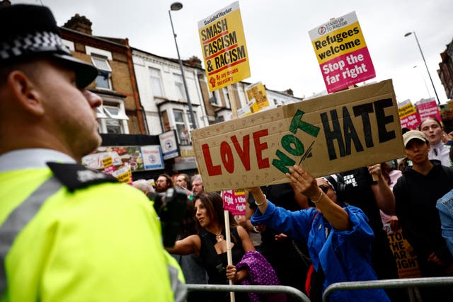 <p>‘Love not hate’ placard held up during an counter-protest against planned anti-immigration event in London </p>