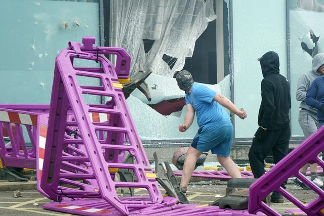 Windows are smashed as trouble flares during an anti-immigration protest outside a hotel in Rotherham, South Yorkshire (PA)
