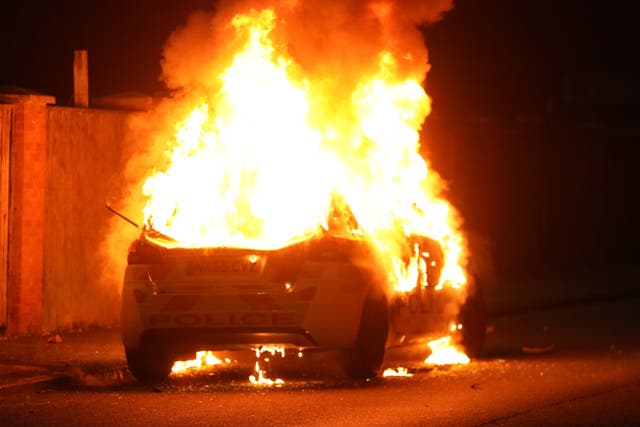 A police car burns as officers are deployed on the streets of Hartlepool following a violent protest (Owen Humphreys/PA)