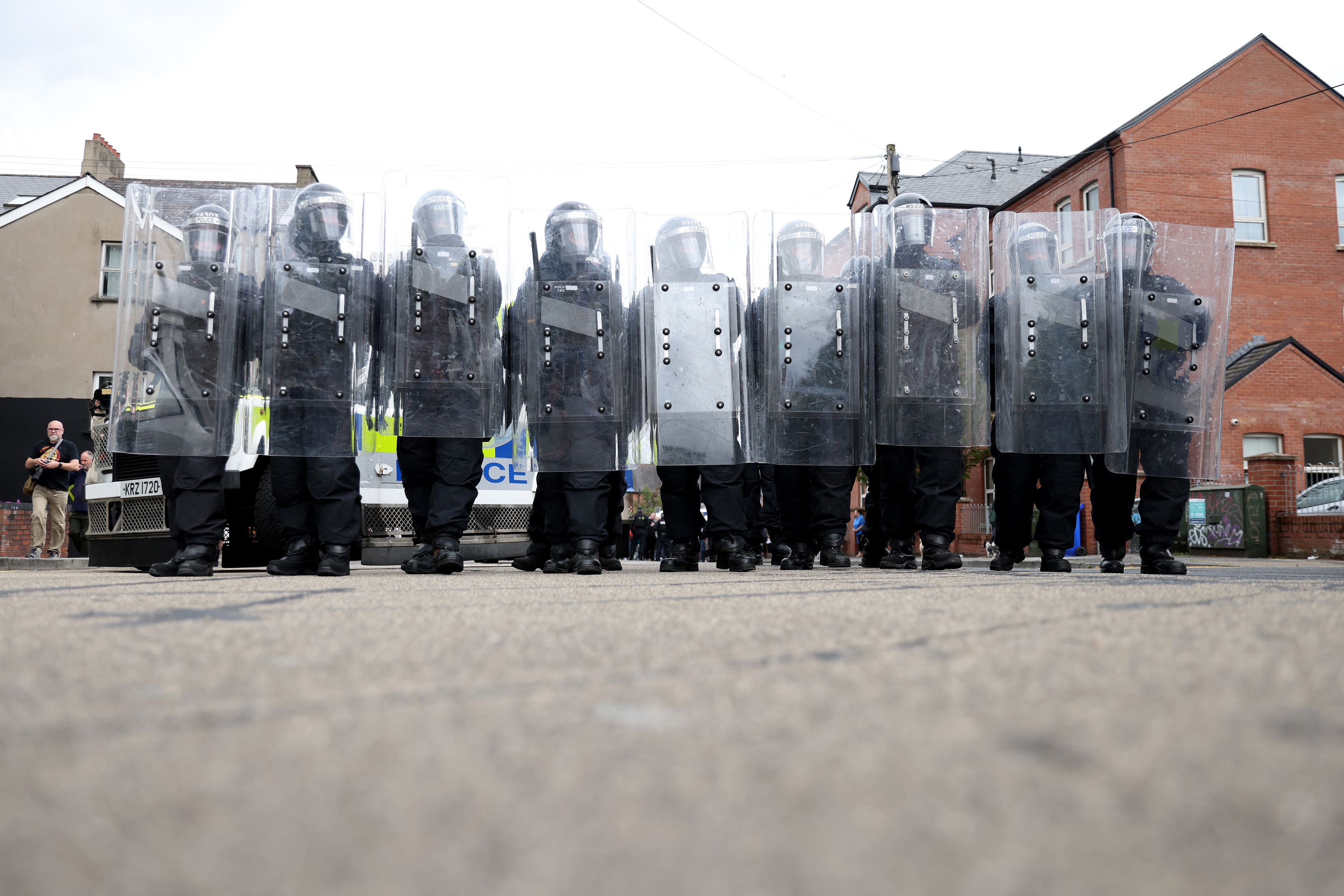 Riot police form a line on the Lower Ormeau Road (PA)