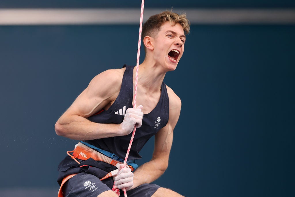 The 19-year-old celebrates after setting the highest score following his lead climb