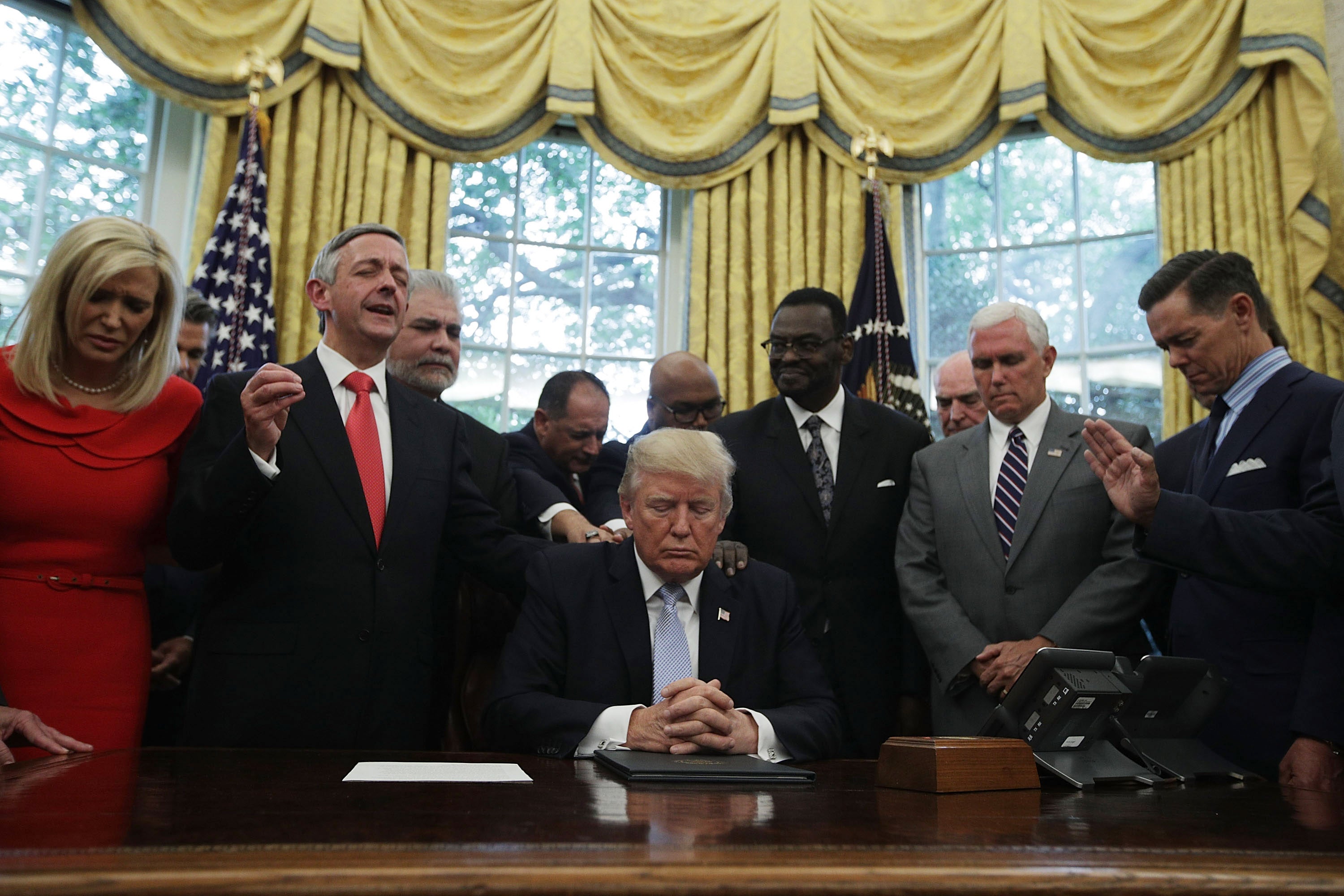 Donald Trump, Mike Pence and faith leaders say a prayer during the signing of a proclamation in the Oval Office in 2017