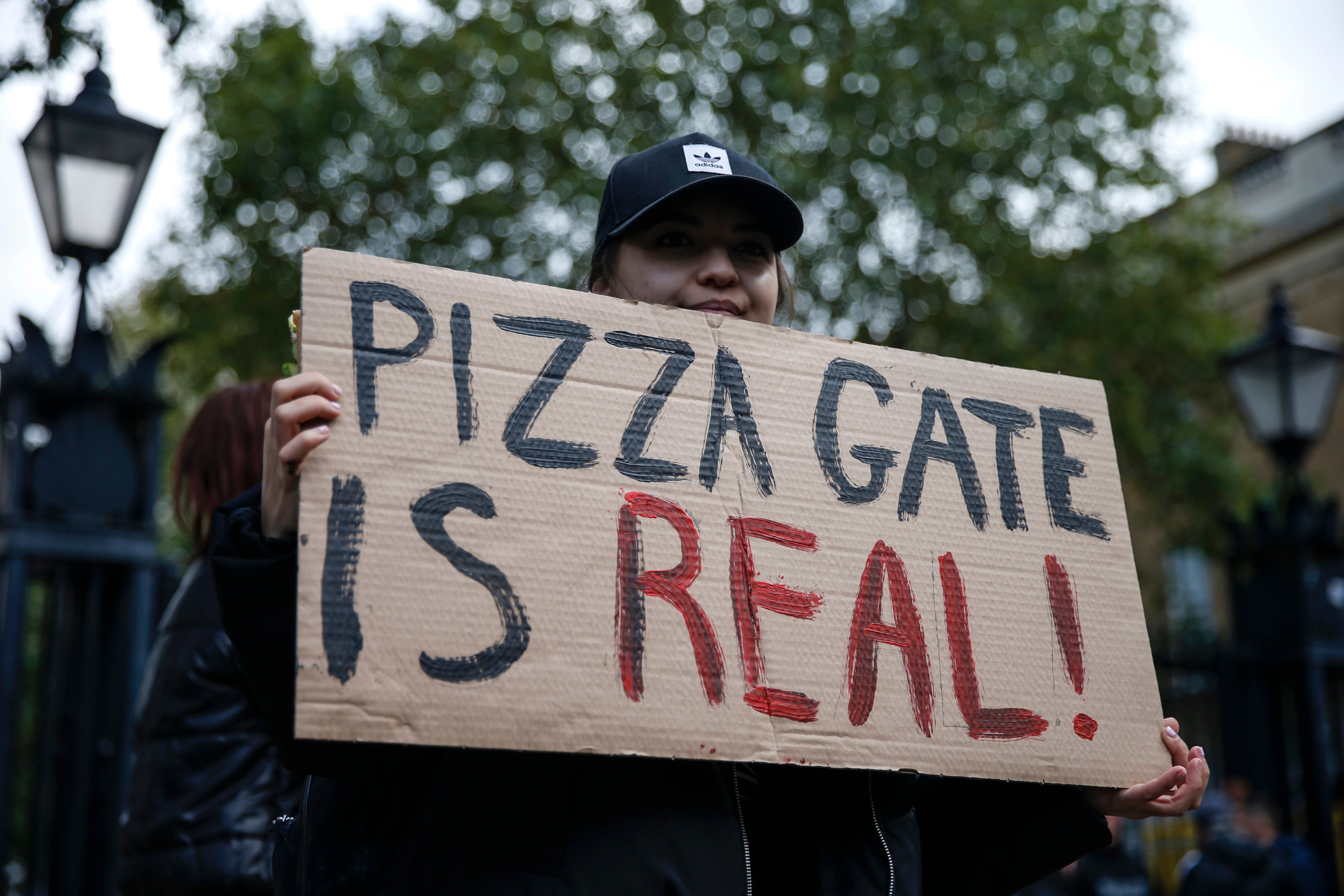 A protestor at a ‘Save Our Children’ rally at Downing Street in 2020, with a sign referencing the confected American conspiracy theory