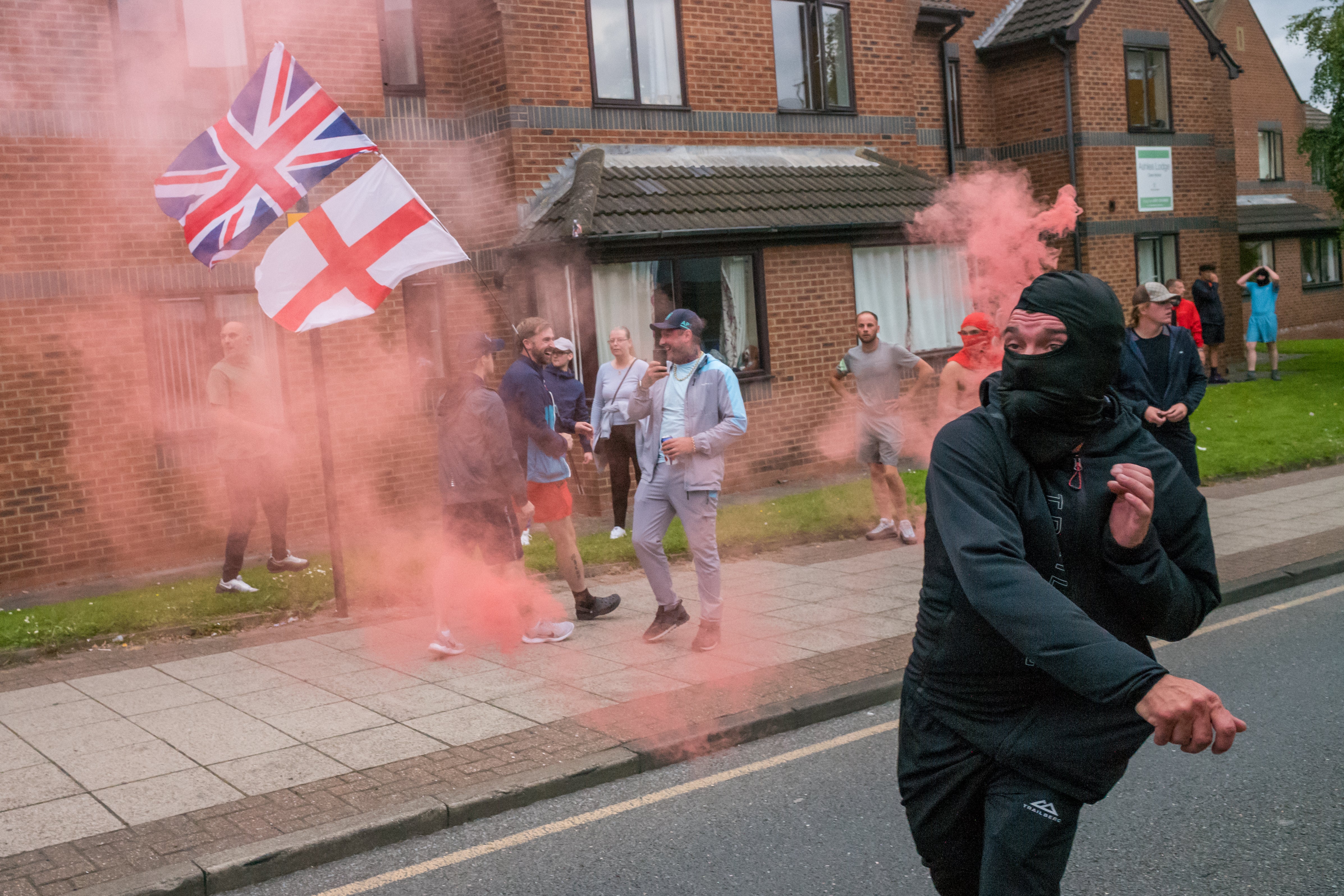 Demonstrator throws smoke flare at police as far-right activists stage protest in Sunderland at the beginning of August (Photo by Ian Forsyth/Getty Images)