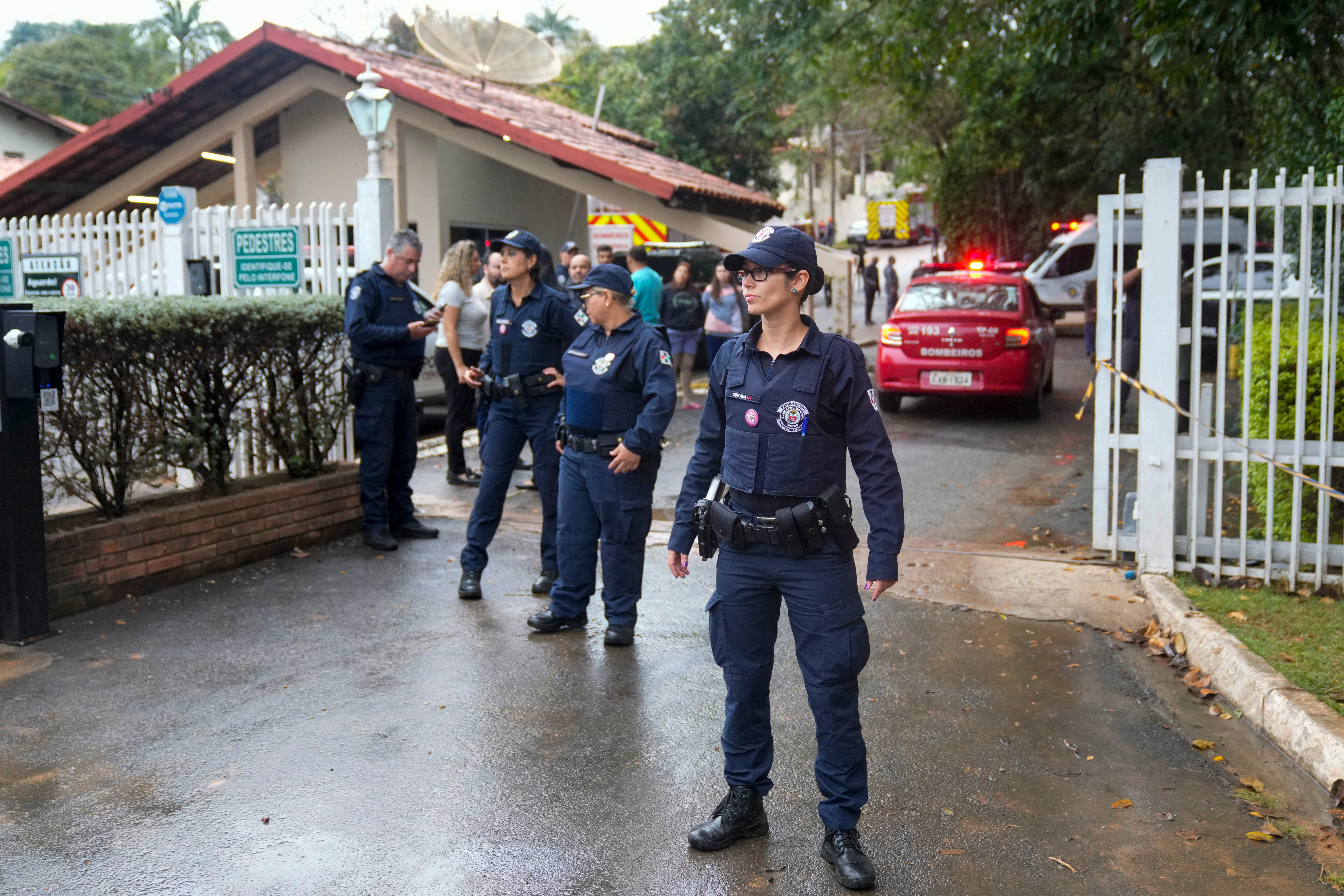 Emergency crews guard the neighborhood where VoePass flight 2283 crashed on Friday afternoon. Officials said the plane crashed into several homes as it spiraled out of the air