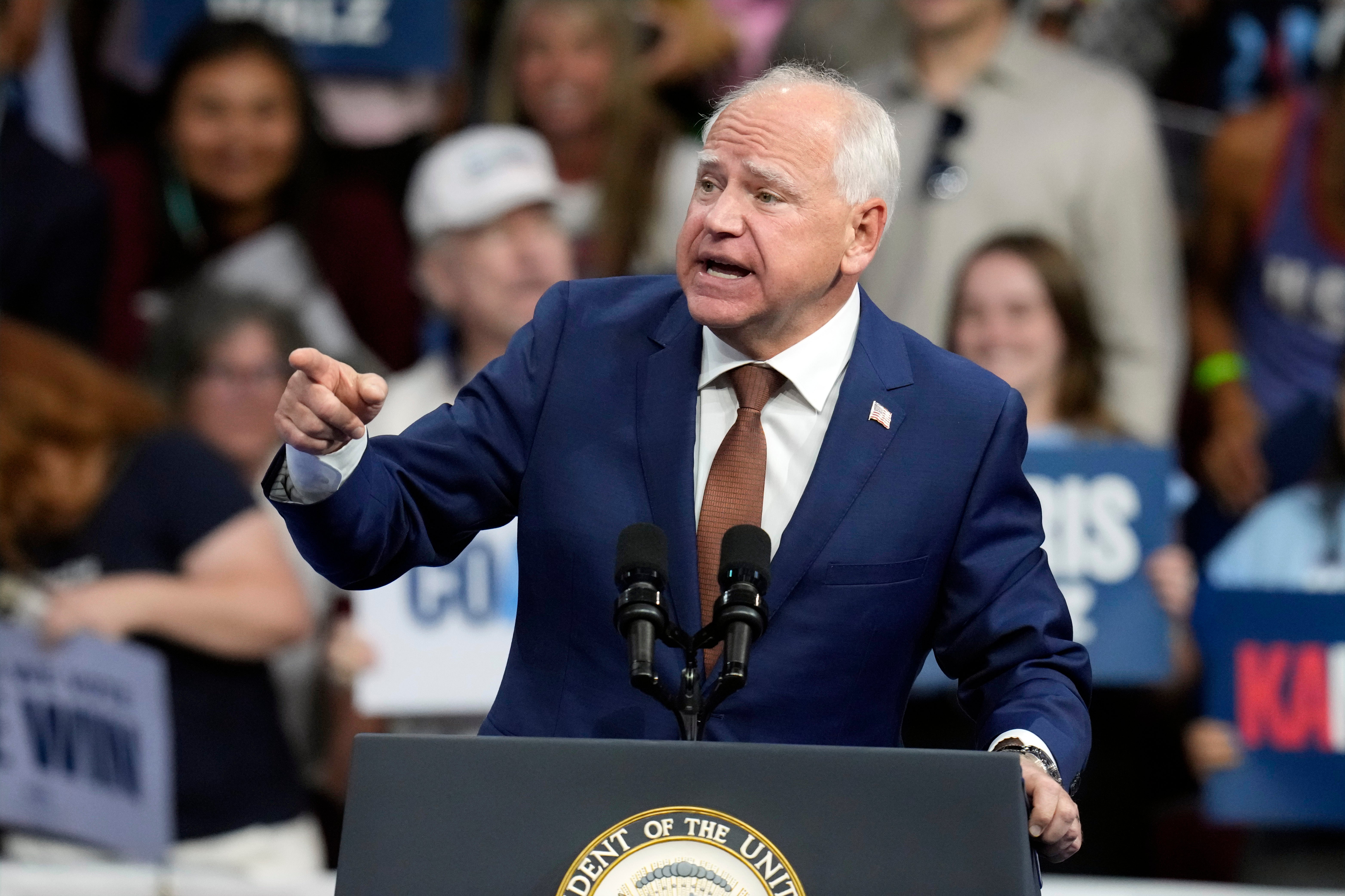 Democratic vice presidential nominee Minnesota Gov. Tim Walz speaks at a campaign rally in Arizona. His campaign is trying to walk back his previous comments about using weapons “in war.”