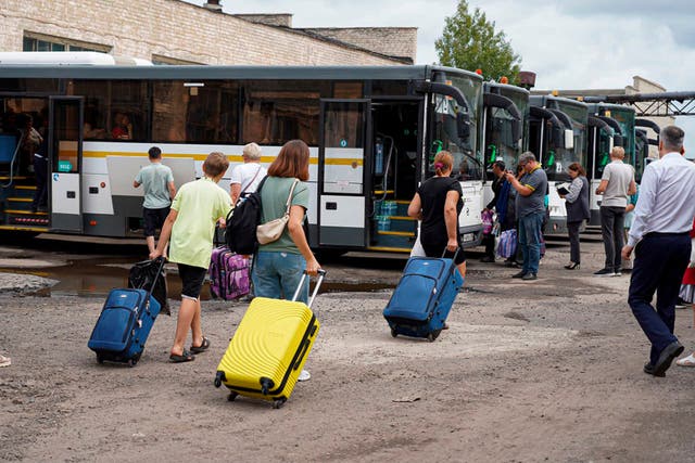 <p>Relatives carry suitcases of their children from the Kursk region helping them to leave for the Moscow region</p>