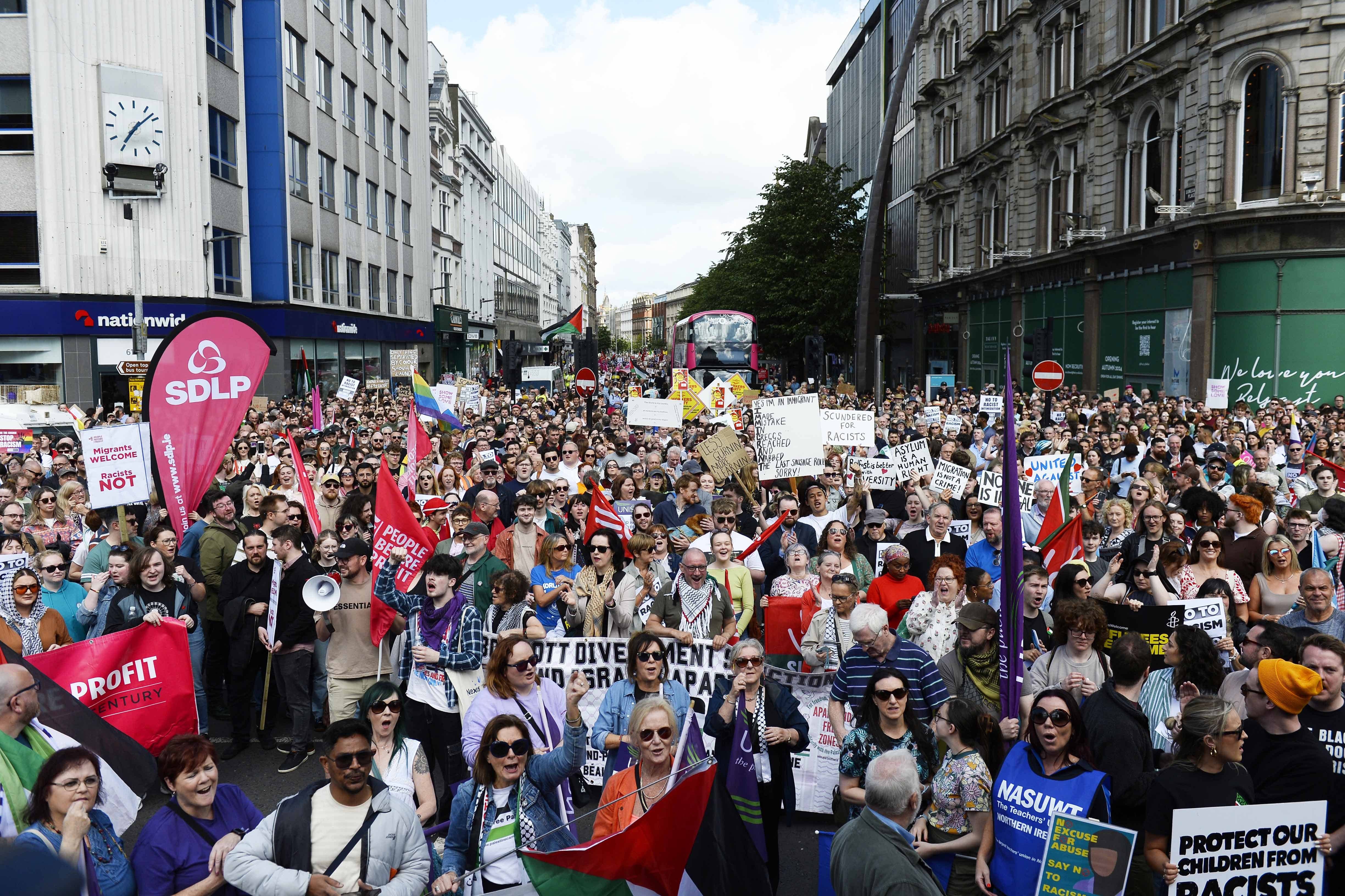 Demonstrators take part in a United Against Racism rally in Belfast (PA)