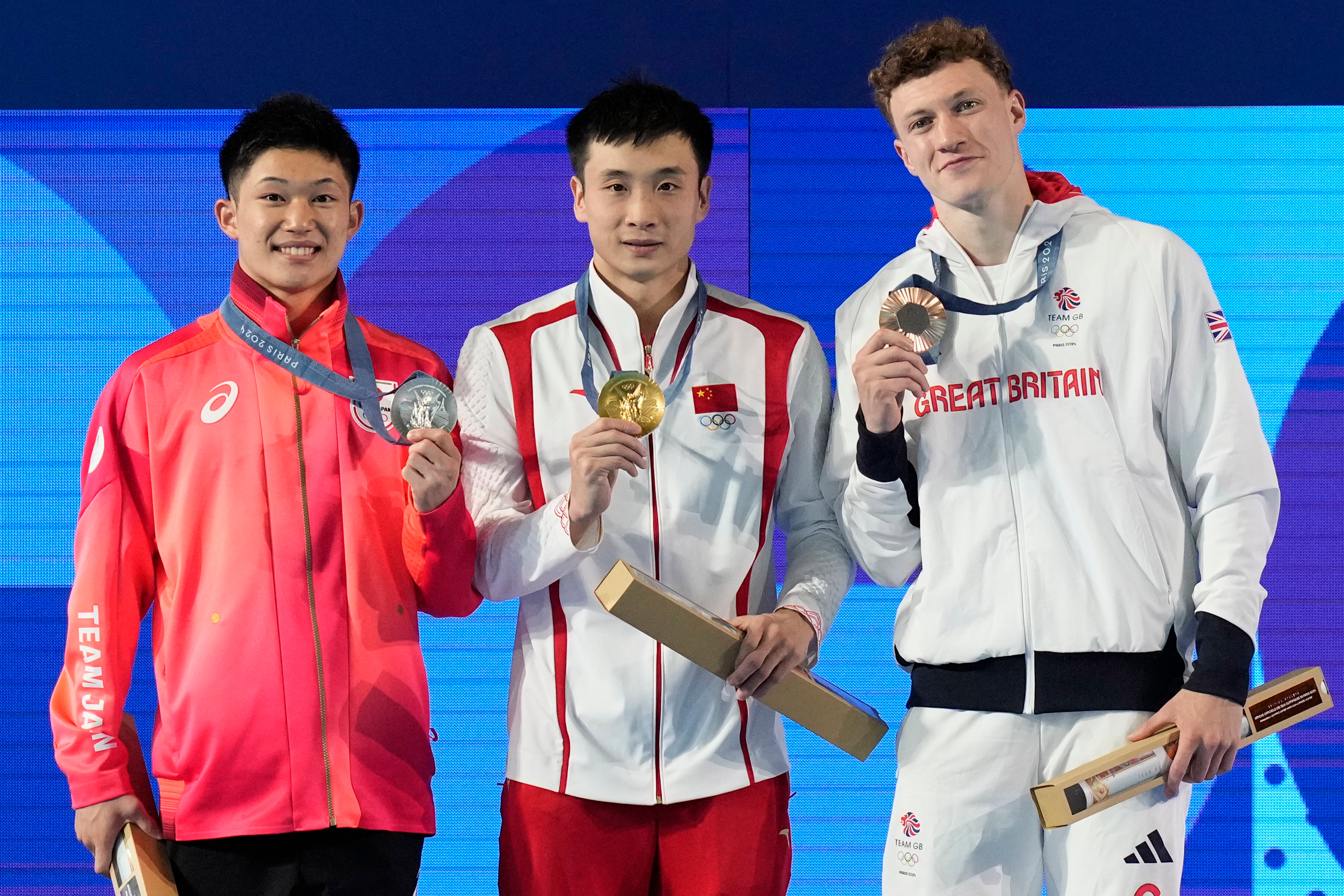 Gold medalist China's Cao Yuan, center, silver medalist Japan's Rikuto Tamai, left, and bronze medalist Britain's Noah Williams stand on the podium