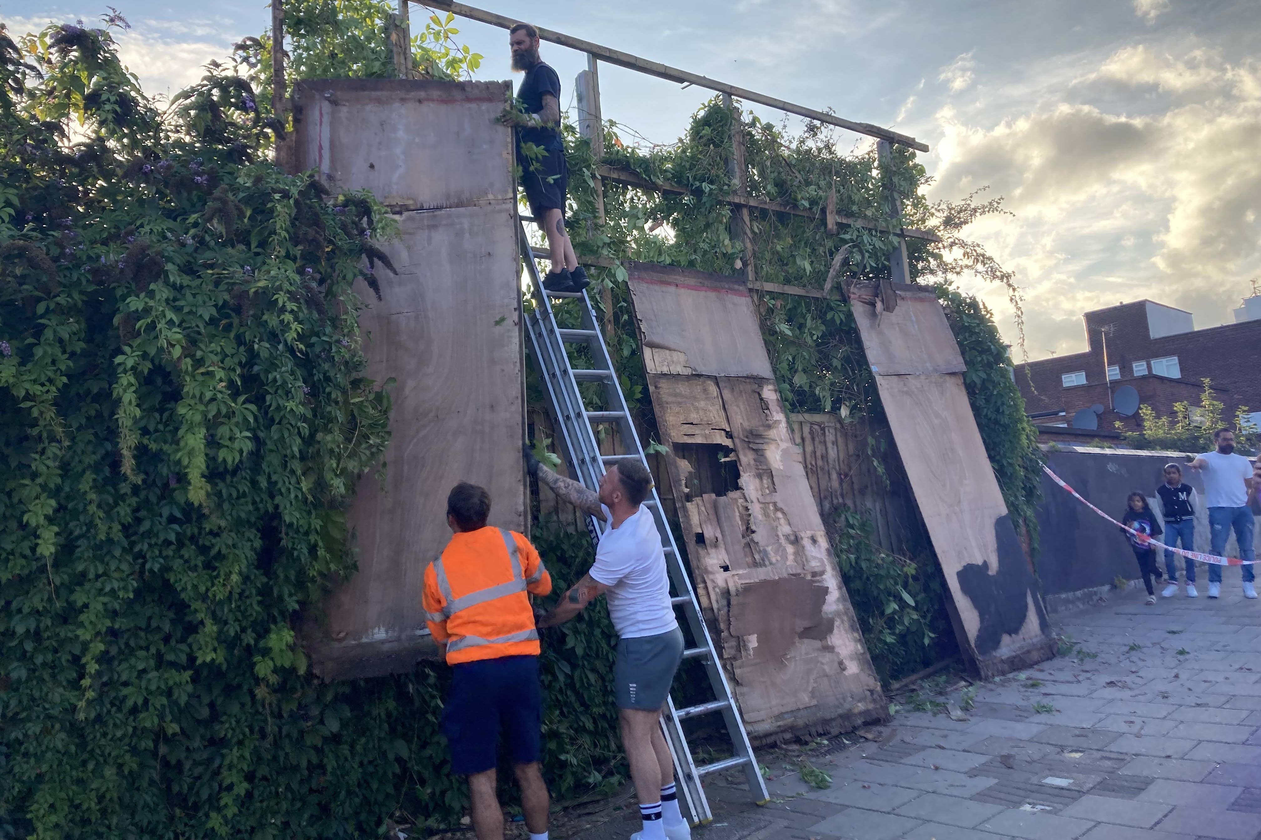 Contractors dismantle a billboard in Cricklewood, north-west London, with the new Banksy artwork depicting a stretching cat that was unveiled on Saturday. (Jordan Reynolds/PA)