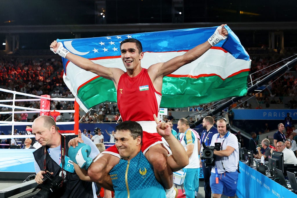 Abdumalik Khalokov of Uzbekistan celebrates winning gold medal with coach Tulkin Kilichev