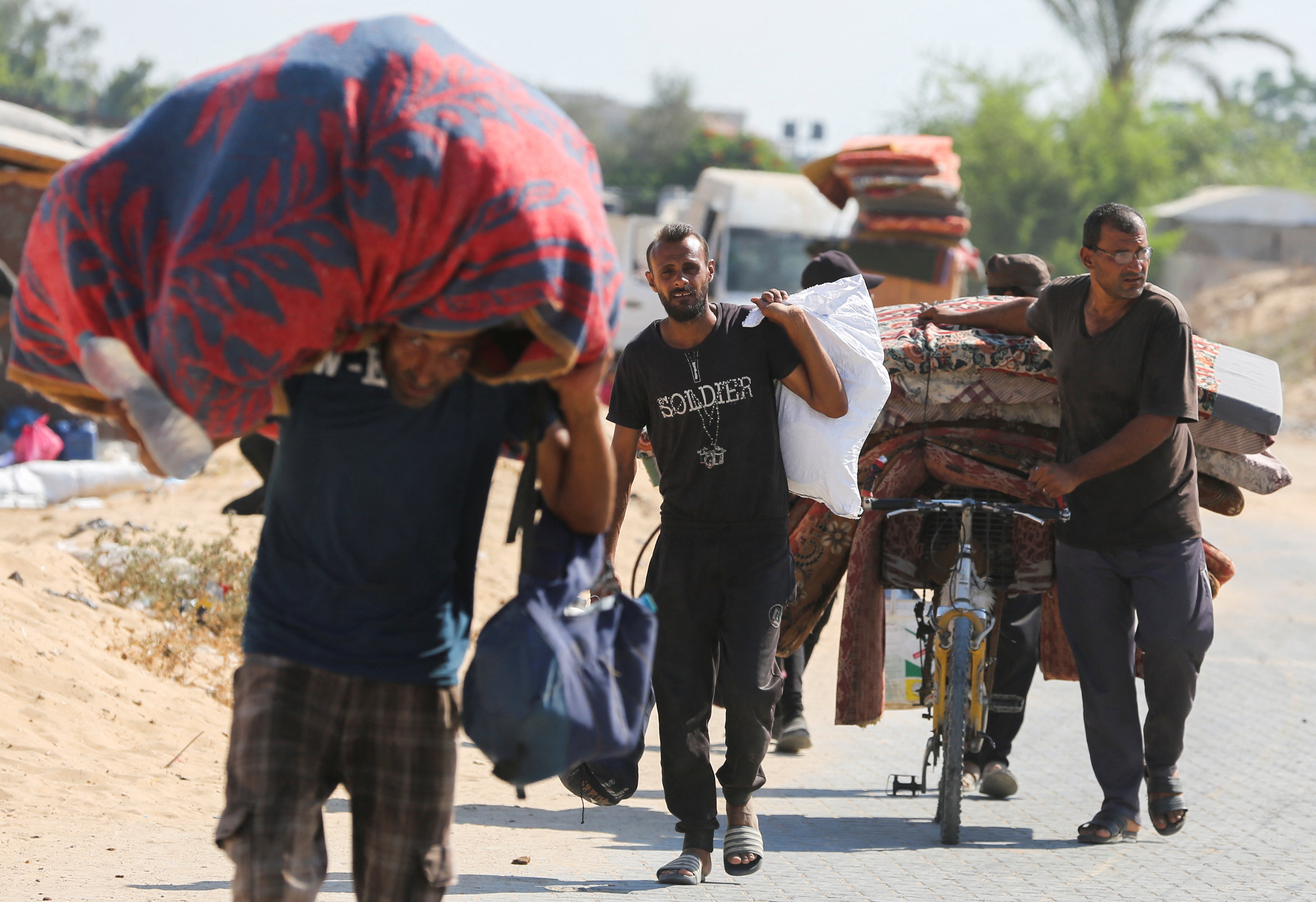 Displaced Palestinians make their way as they flee Hamad City