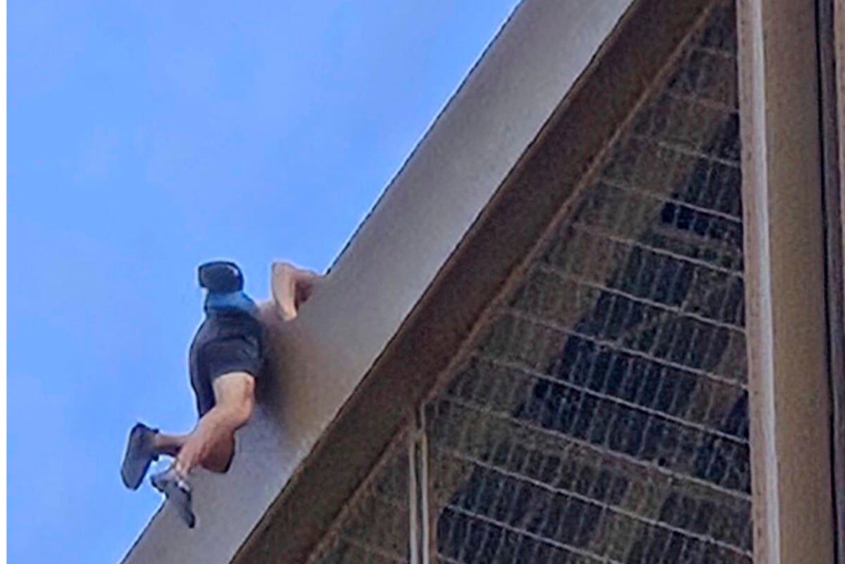 A man climbs the Eiffel Tower, during the 2024 Summer Olympics