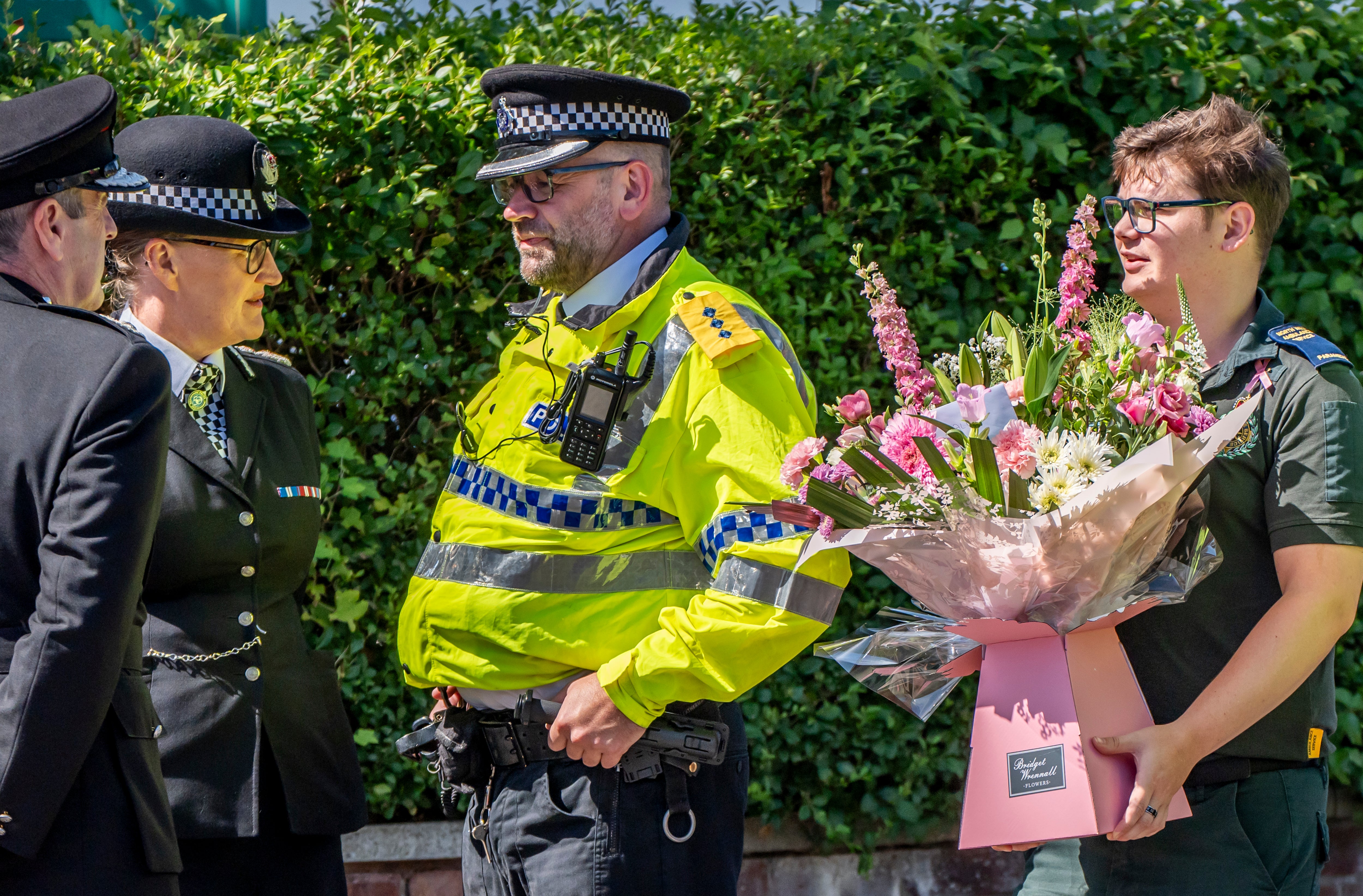 Merseyside Police Chief Constable Serena Kennedy (second left) looks on as paramedic carries flowers