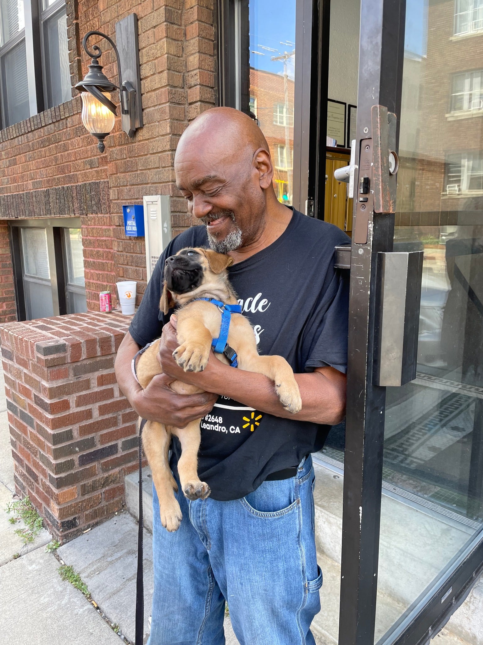 A man holds a puppy and smiles after Minneapolis police returned the stolen canine on August 9, 2024.