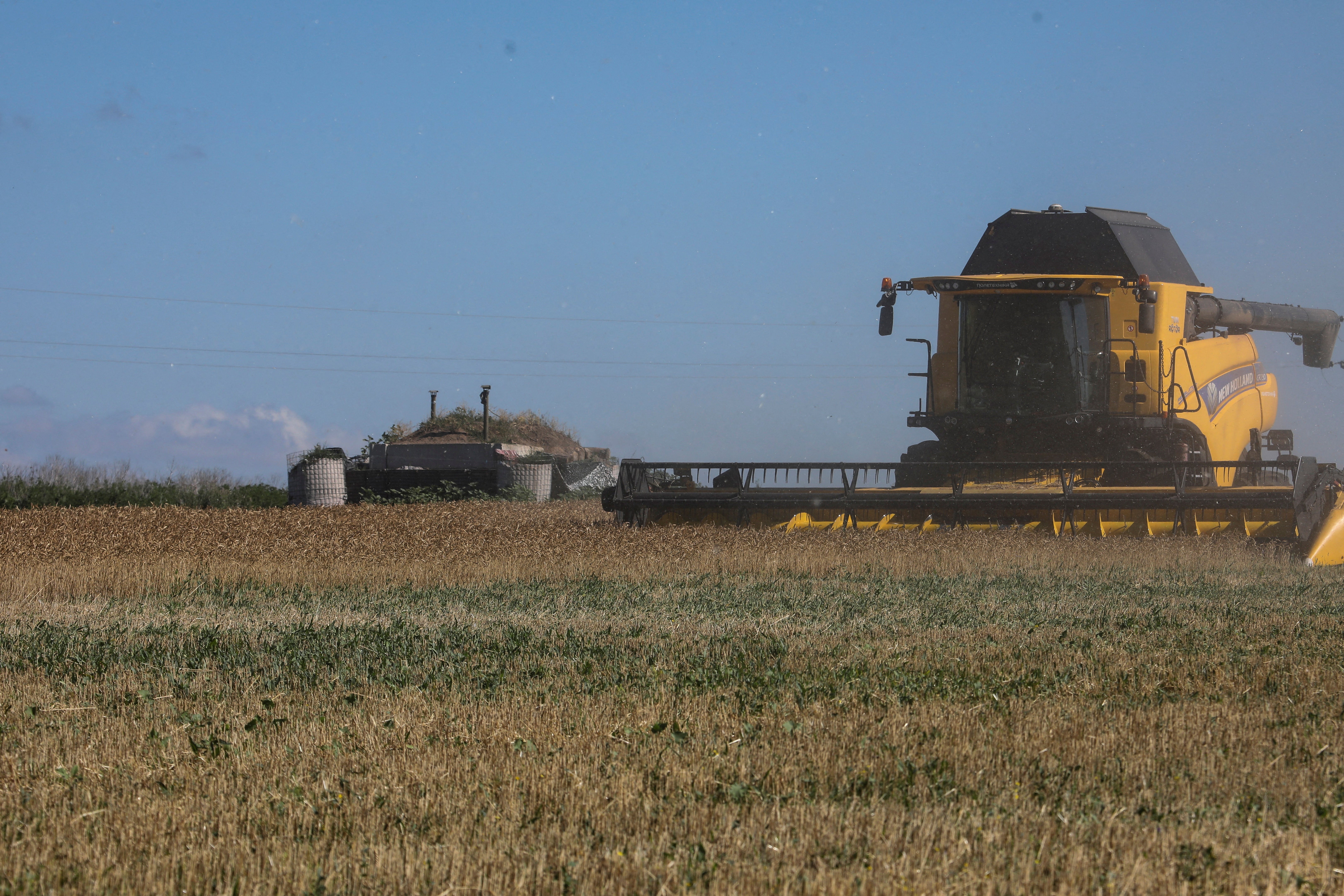 An agricultural worker operates a combine during wheat harvesting in a field last month in the Kharkiv region, northern Ukraine