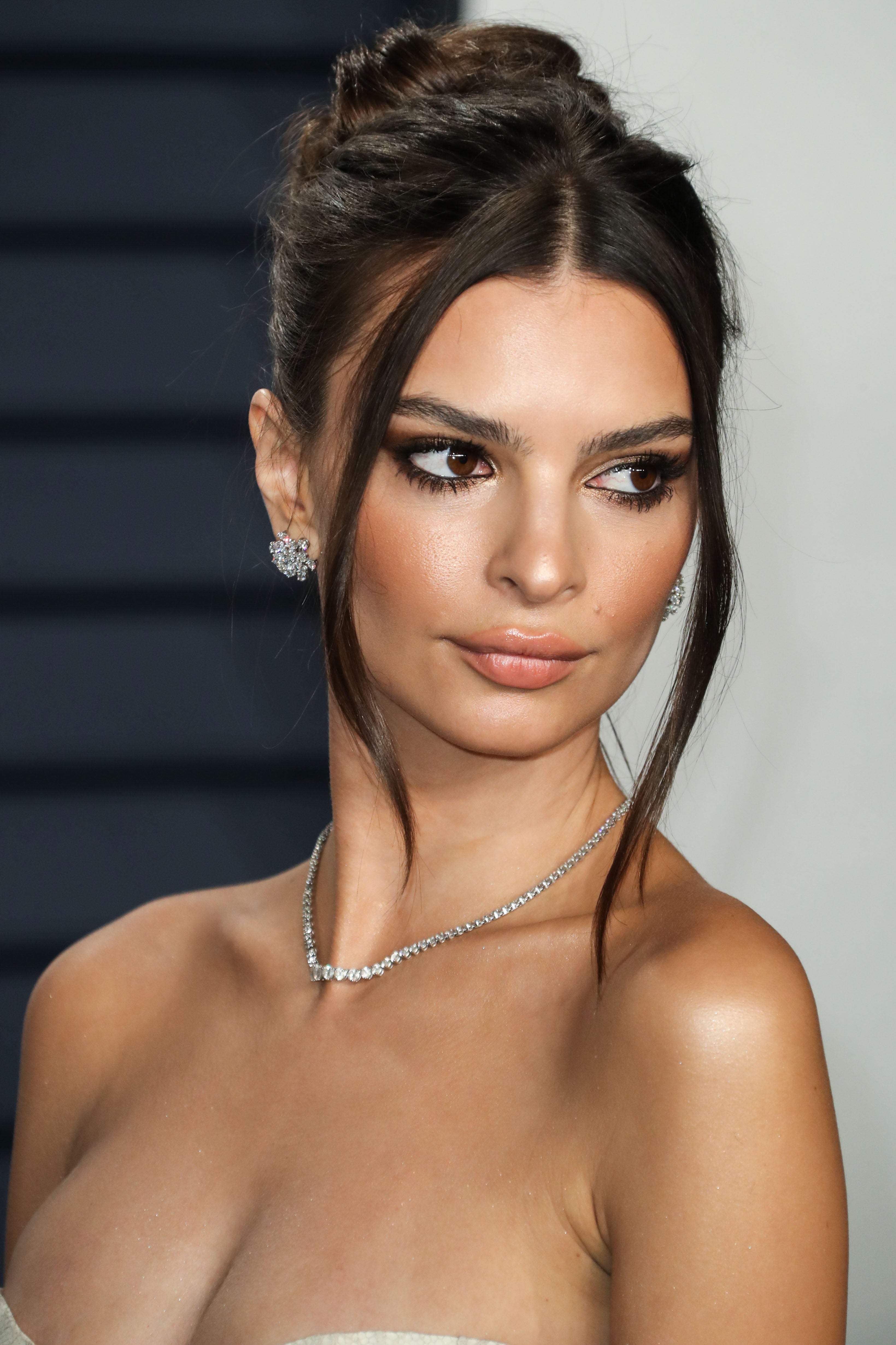 Emily Ratajkowski wears a tousled bun both on and off duty (Alamy/PA)