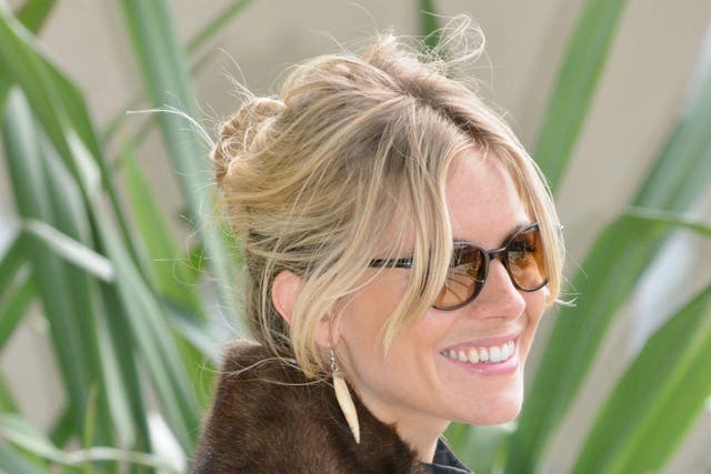 Sienna Miller sports the undone bun to get her hair off her neck (Alamy/PA)