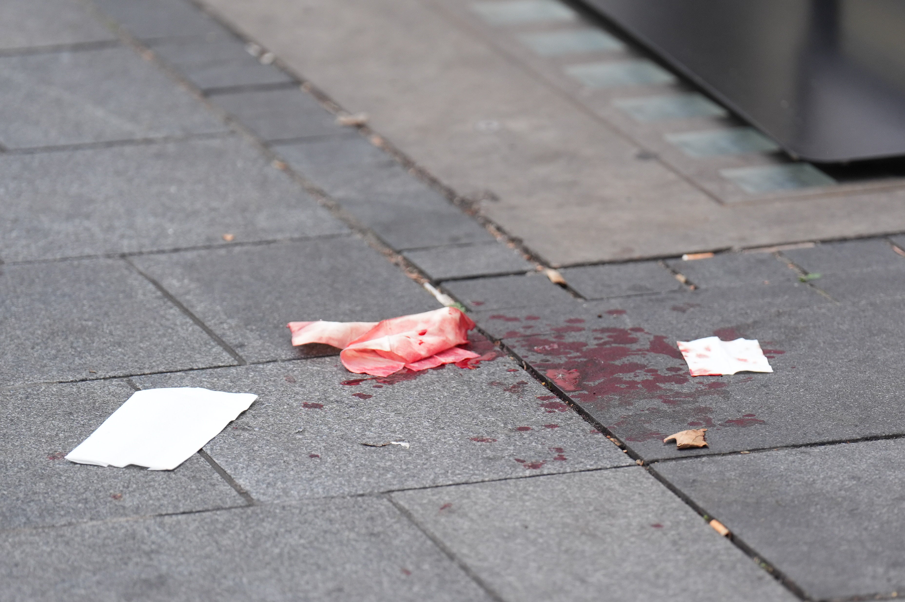 Blood on the pavement at the scene opposite the M&M store