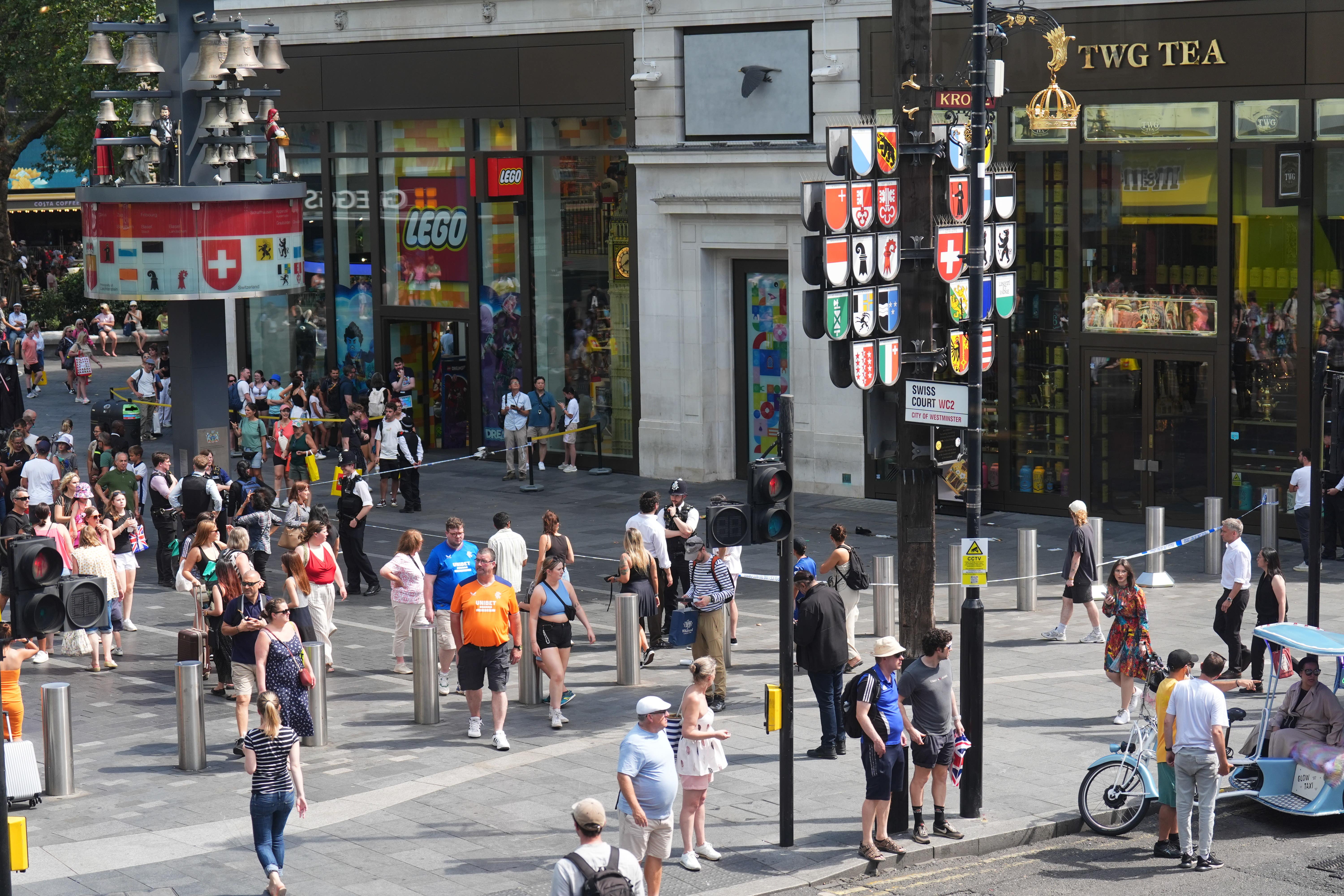 Police officers at the scene in Leicester Square, London, as a man has been arrested after an 11-year-old girl and 34-year-old woman were stabbed (James Manning/PA)