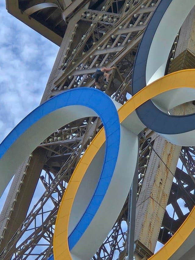 <p>In this photo provided by Nicky Worlock, a man climbs the Eiffel Tower, during the 2024 Summer Olympics, Sunday, Aug. 11, 2024, in Paris France. (Nickey Worlock via AP)</p>