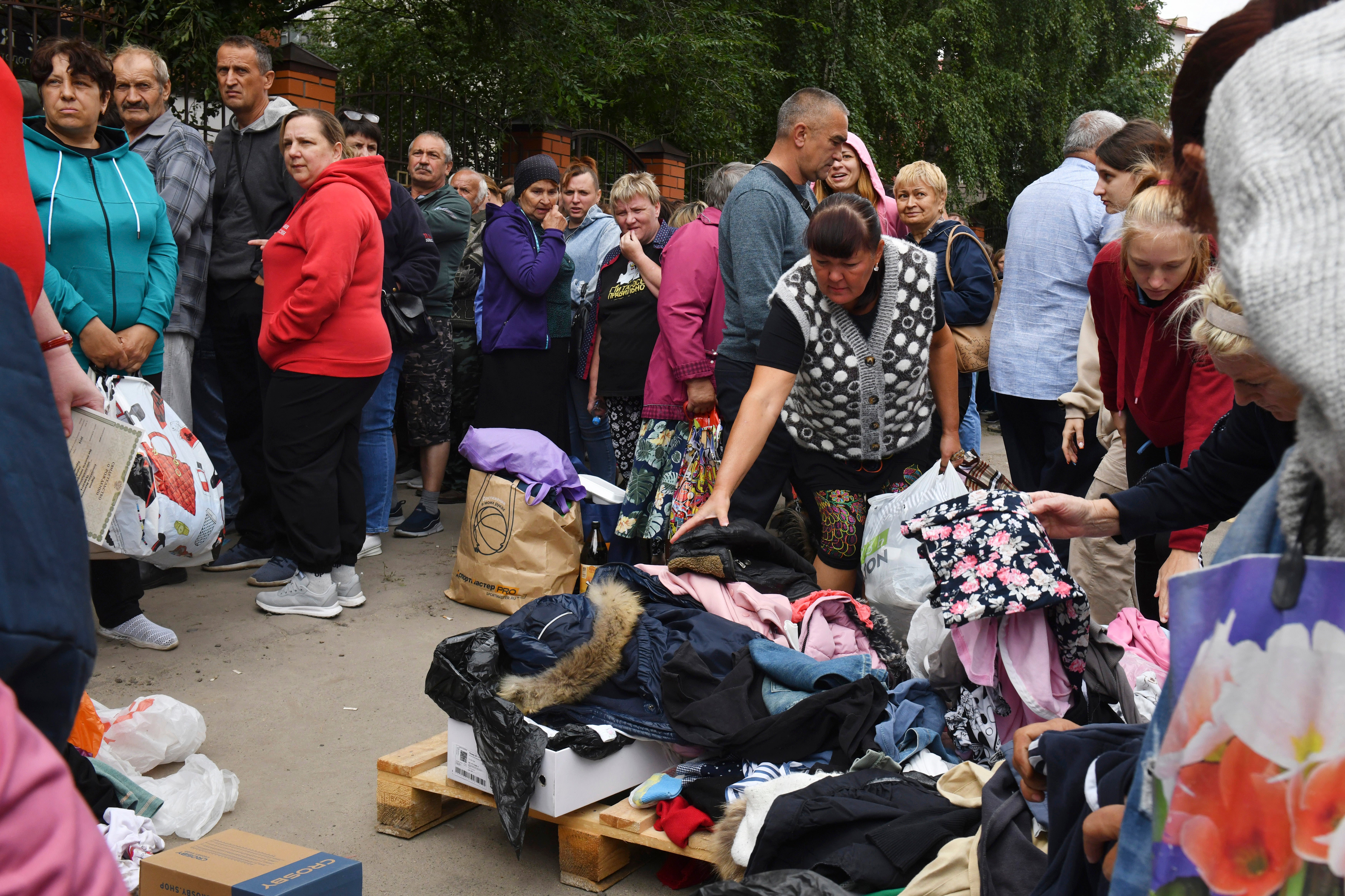 People evacuated from fighting between Russian and Ukrainian forces queue to receive humanitarian aid at a distribution center in Kursk, Russia