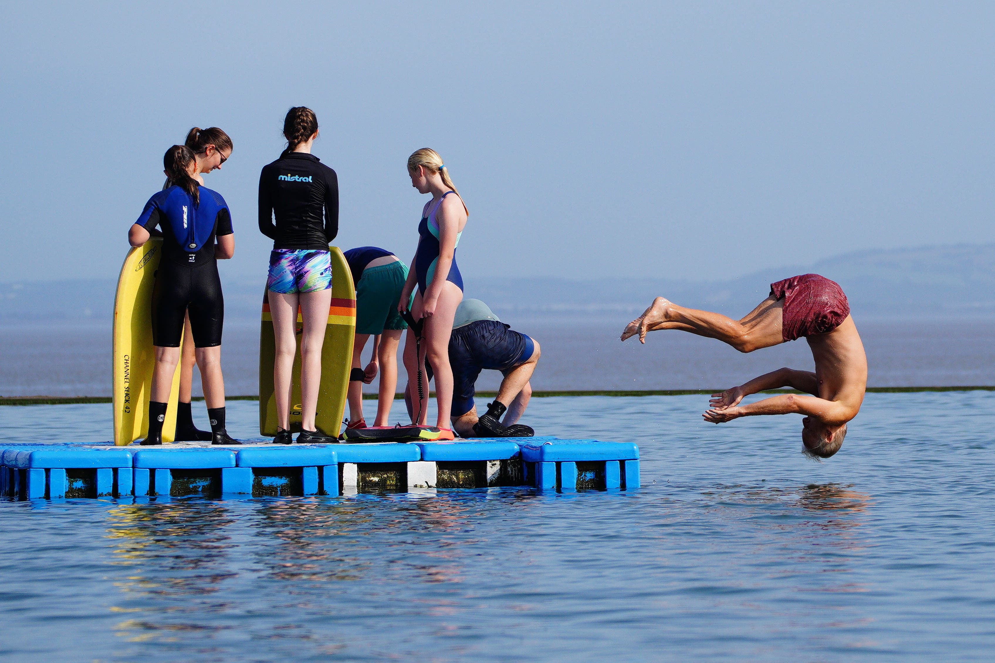 Children leap off a pontoon at Clevedon Marine Lake in Somerset (Ben Birchall/PA)