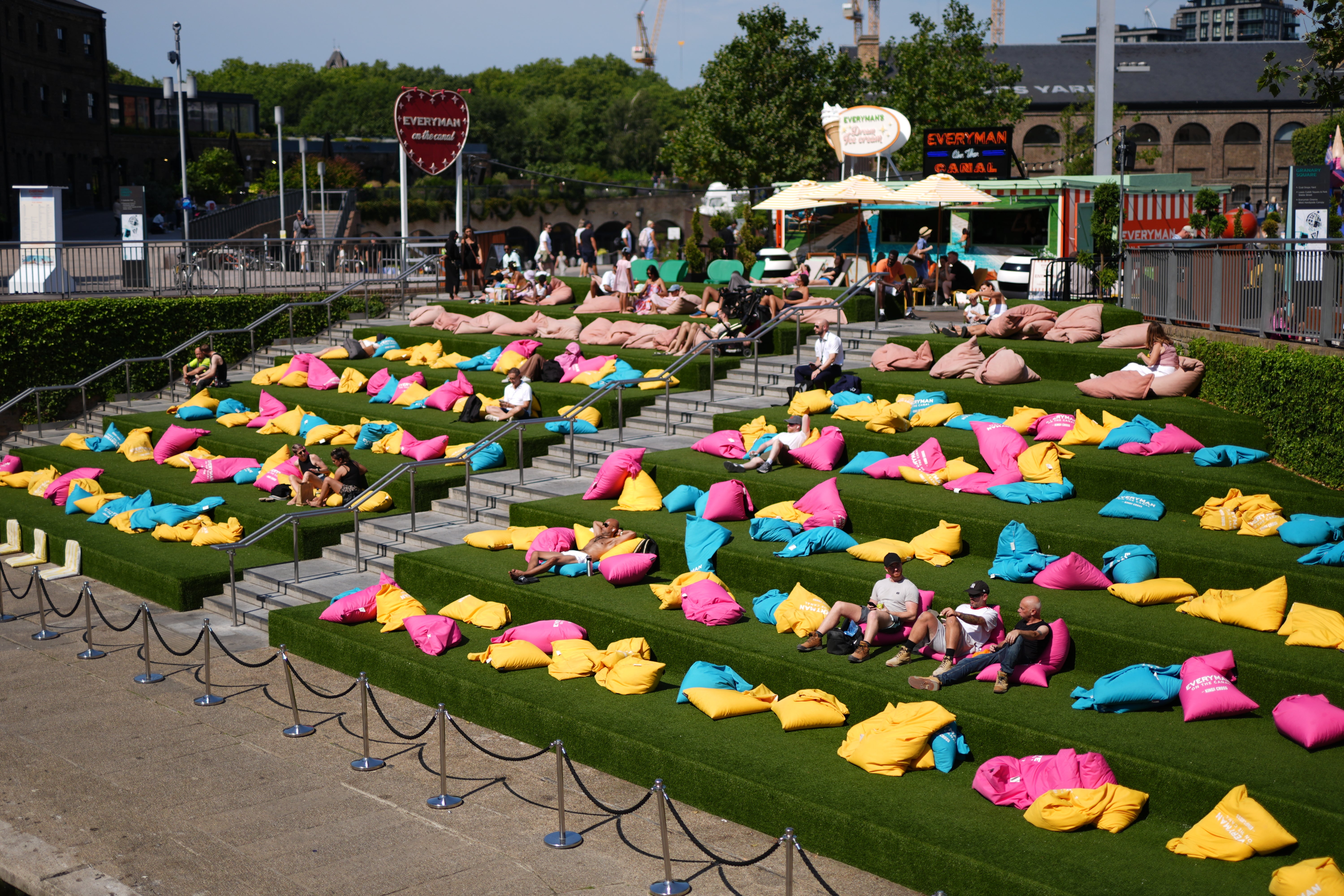 People enjoy the warm weather in Granary Square, London (Jordan Pettitt/PA)