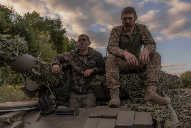 <p>A Ukrainian tank crew take a break while operating a Soviet-made T-72 tank in the Sumy region, near the border with Russia</p>