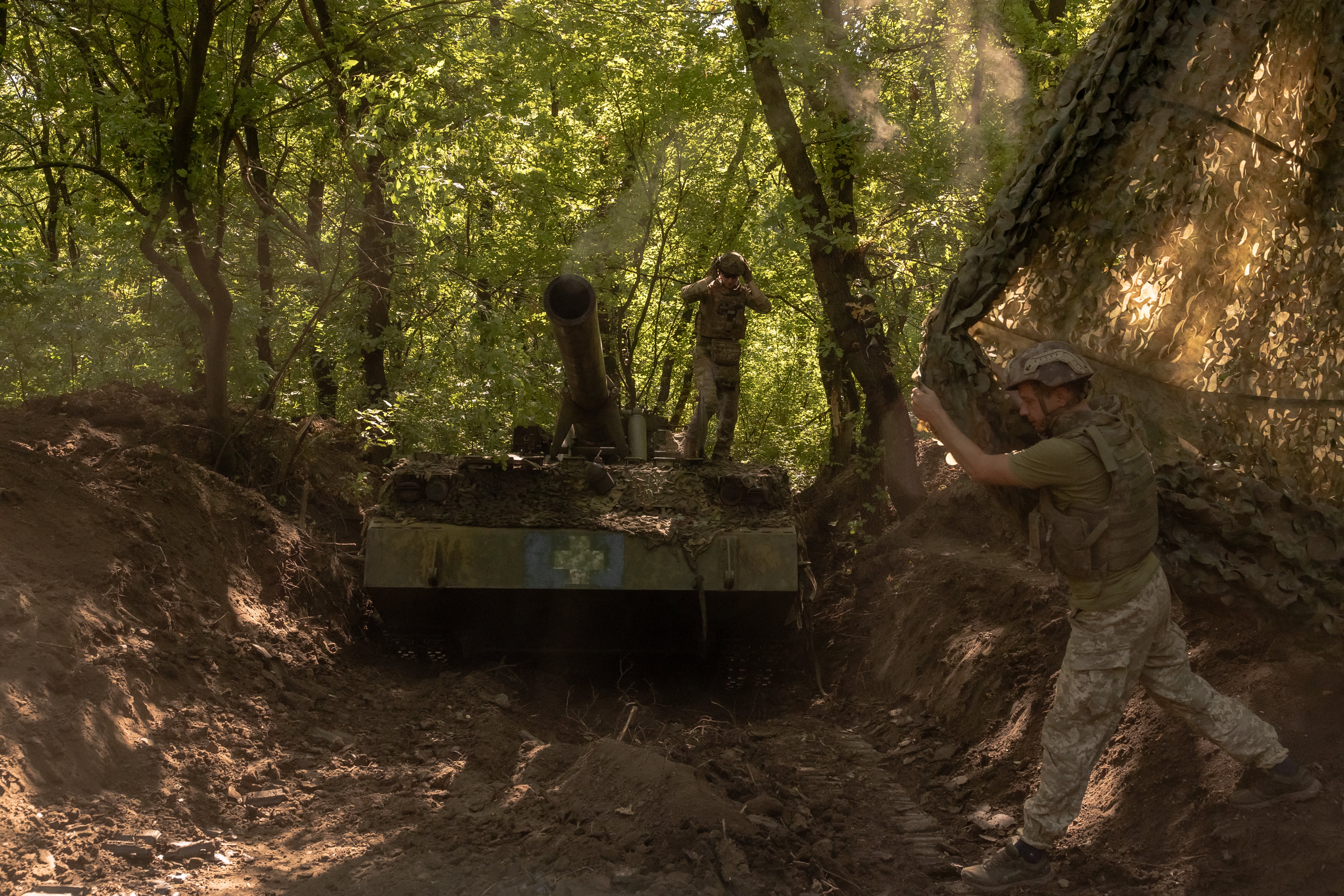 Ukrainian servicemen of the 43rd Artillery Brigade cover self-propelled artillery 2S7 Pion after firing toward Russian positions, in an undisclosed area, in the Pokrovsk district, in the eastern Donetsk region