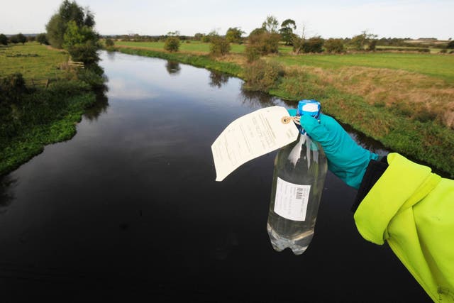 FILE IMAGE: An Environment Agency worker holds a sample from river contaminated with cyanide (Rui Vieira/PA)