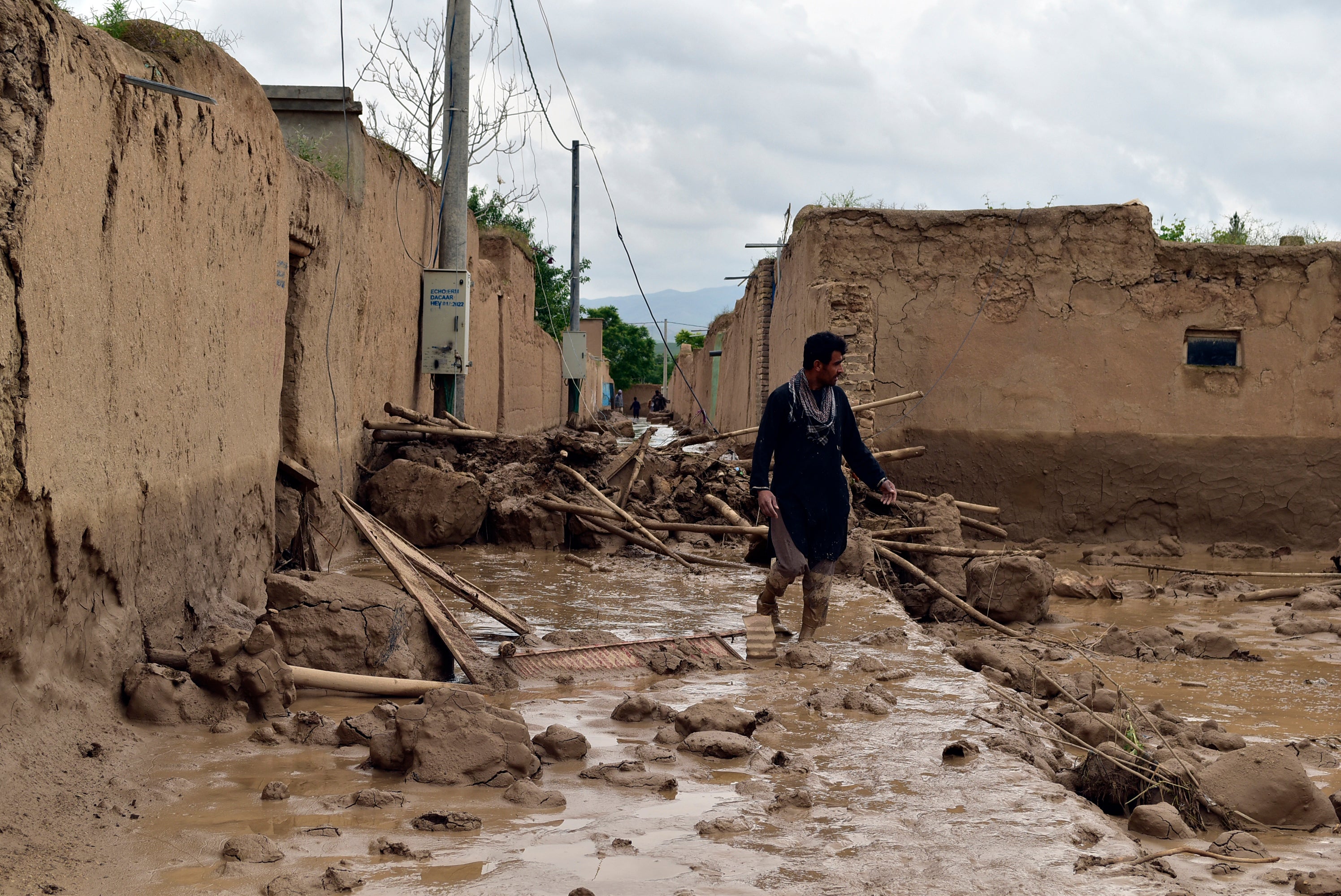 An Afghan man walks near his damaged home after heavy flooding in Baghlan province in northern Afghanistan, 11 May 2024