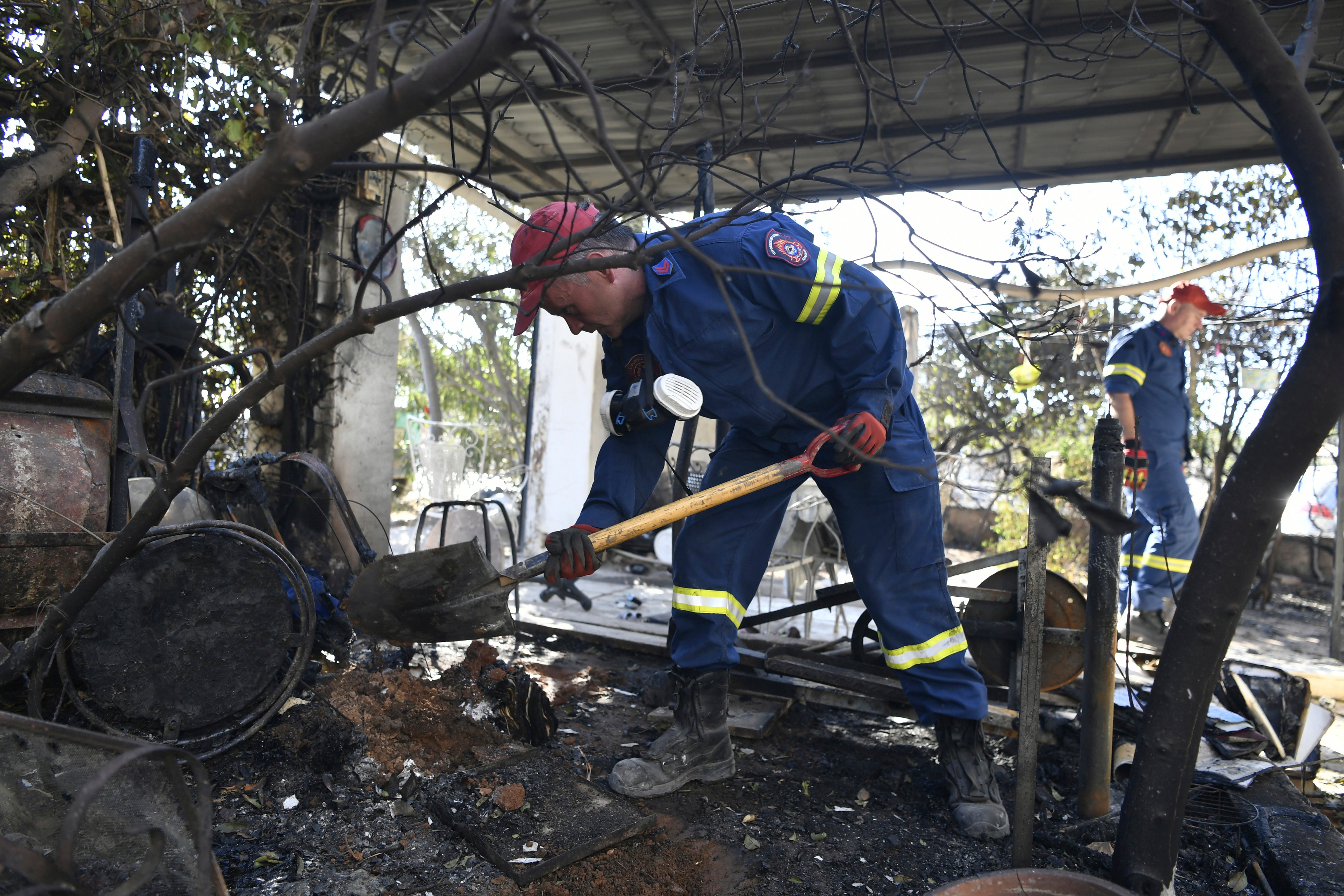 I vigili del fuoco lavorano all'esterno di una casa danneggiata nel sobborgo Chalandri di Atene