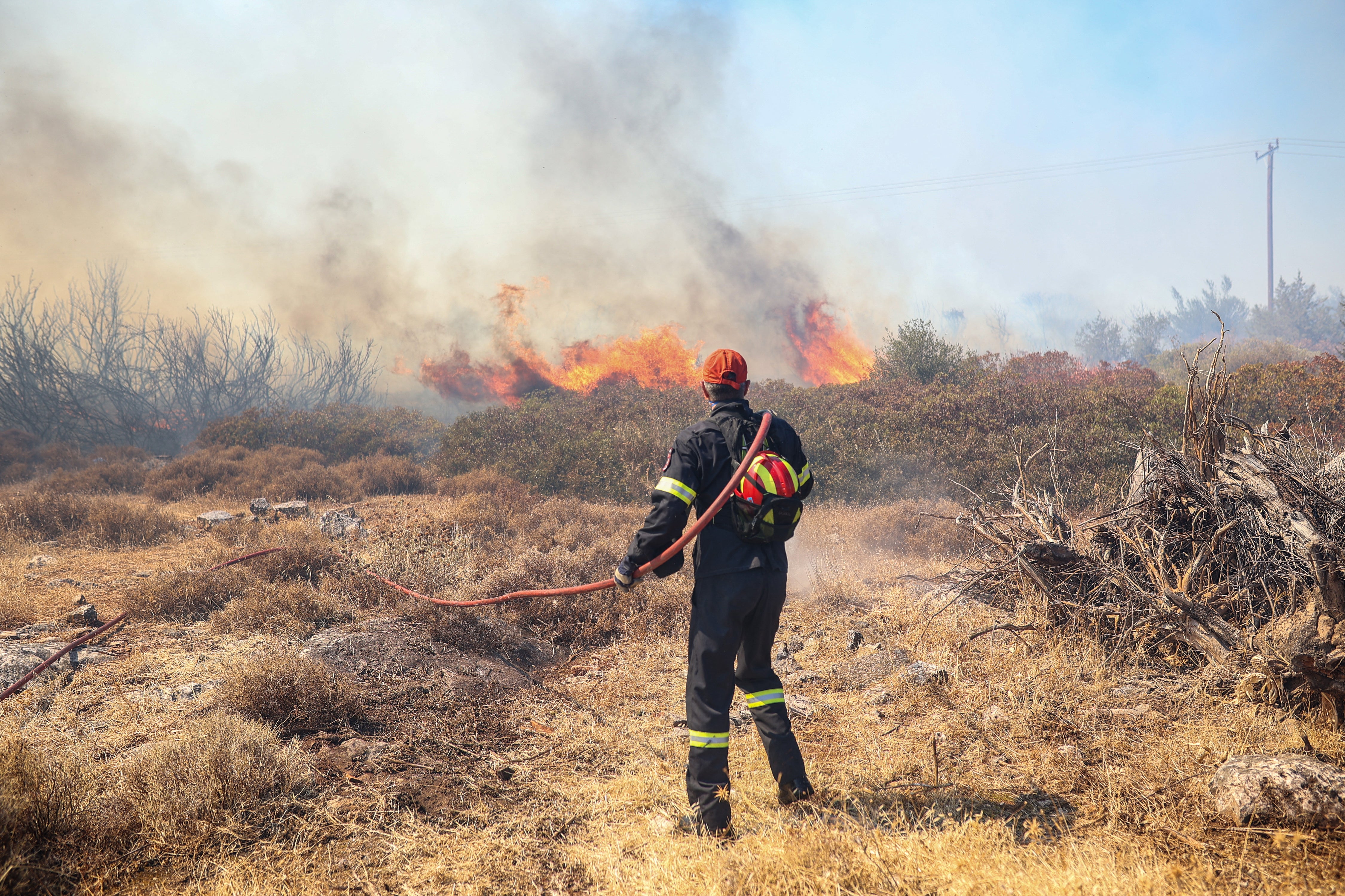 Firefighters attempt to extinguish a wildfire in the Ano Souli region in Attica, on August 12, 2024