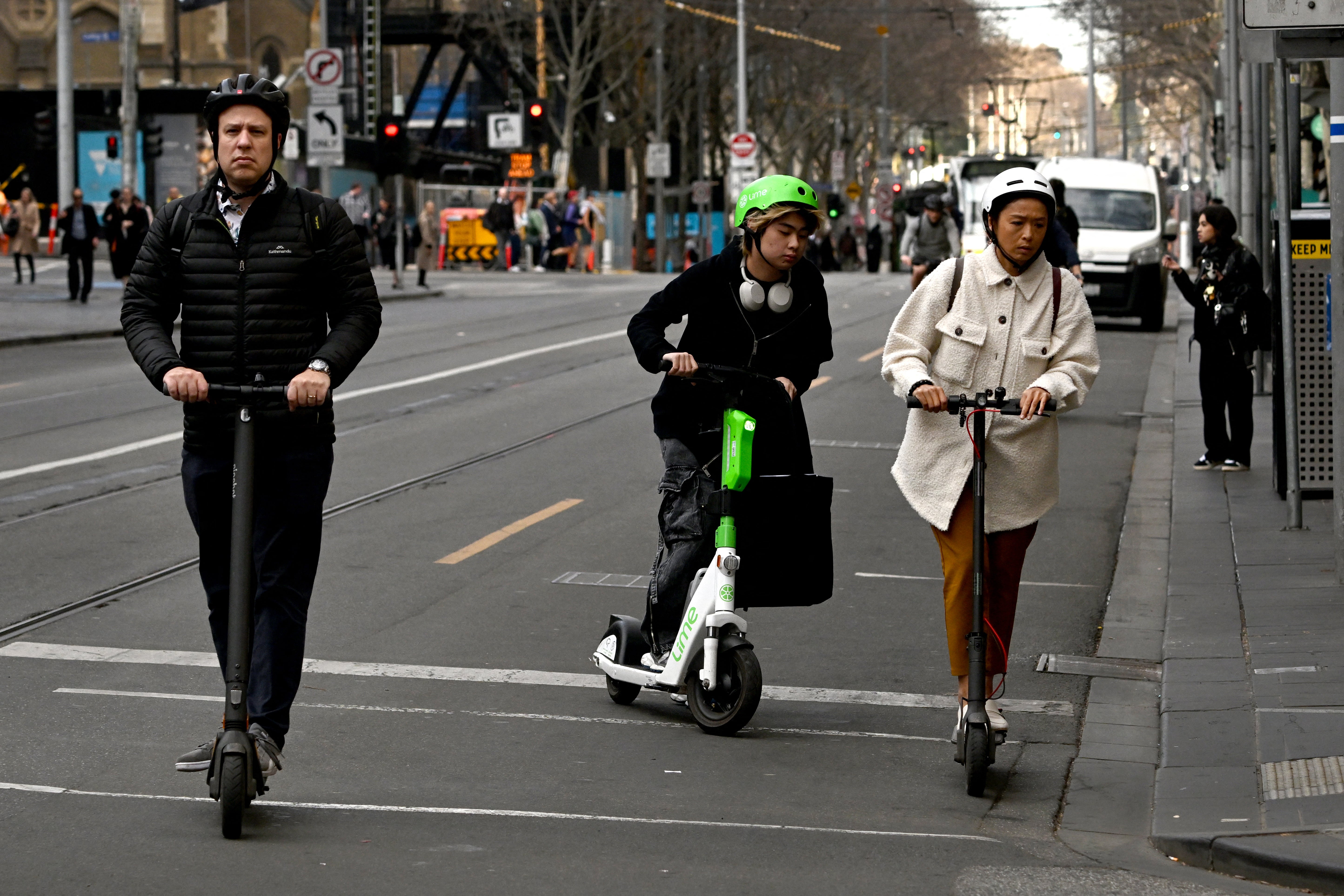 On August 14, 2024, people ride electric scooters through Melbourne's central business district