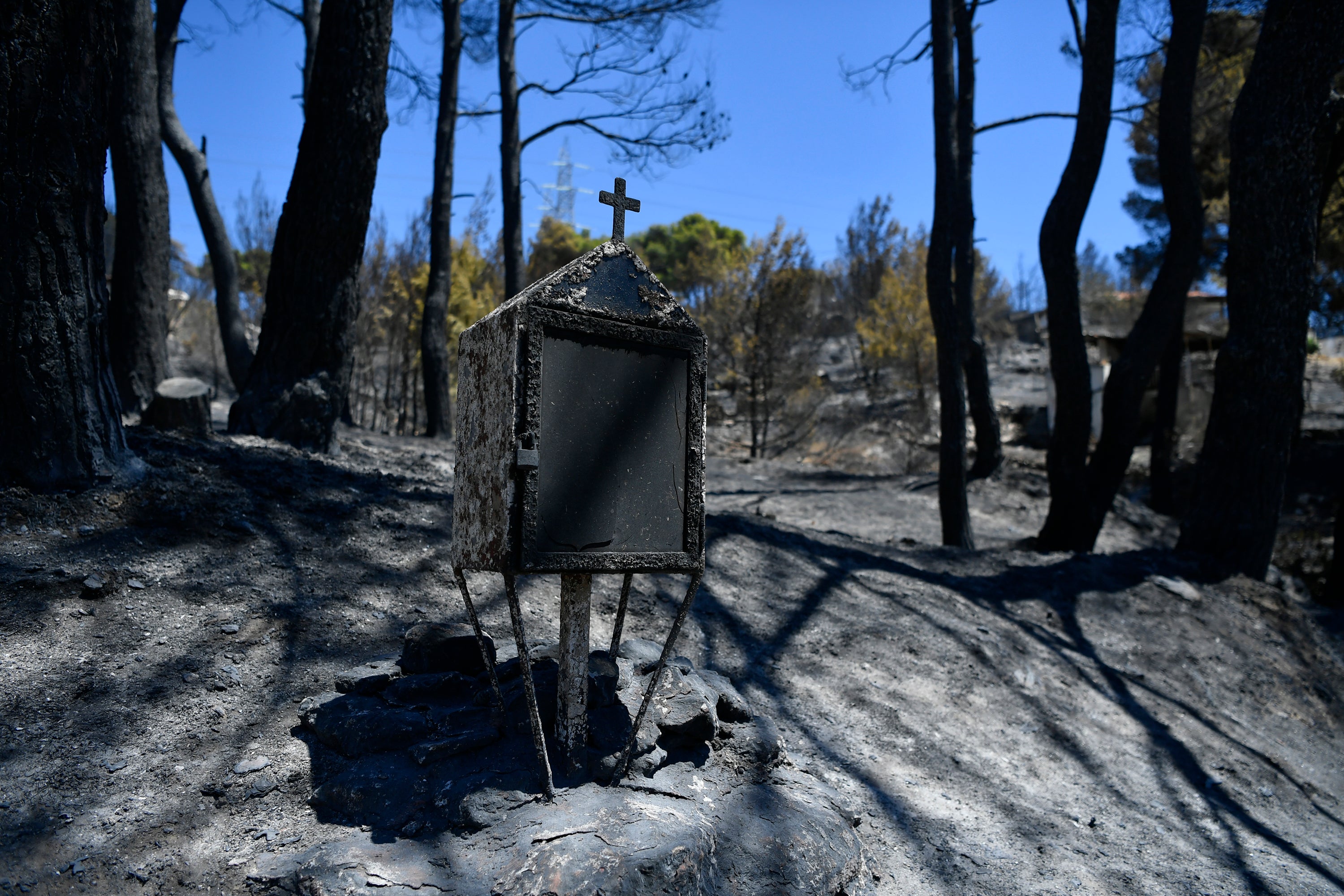 A burned roadside shrine stands in Nea Penteli suburb of Athens, on Tuesday