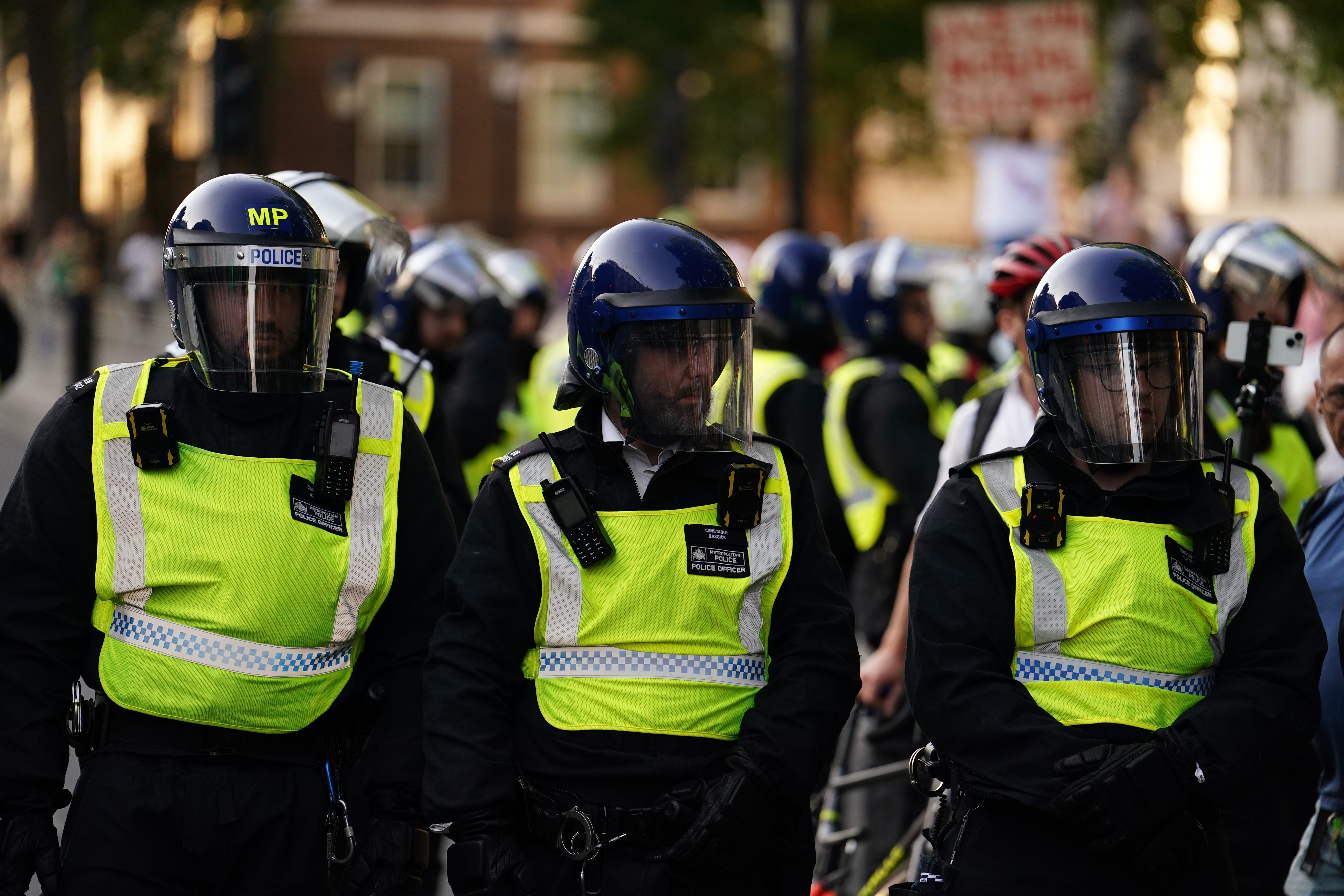 Police officers look on as people attend a protest in Whitehall, London, following the fatal stabbing of three children at a Taylor Swift-themed holiday club on Monday in Southport (Jordan Pettitt/PA)