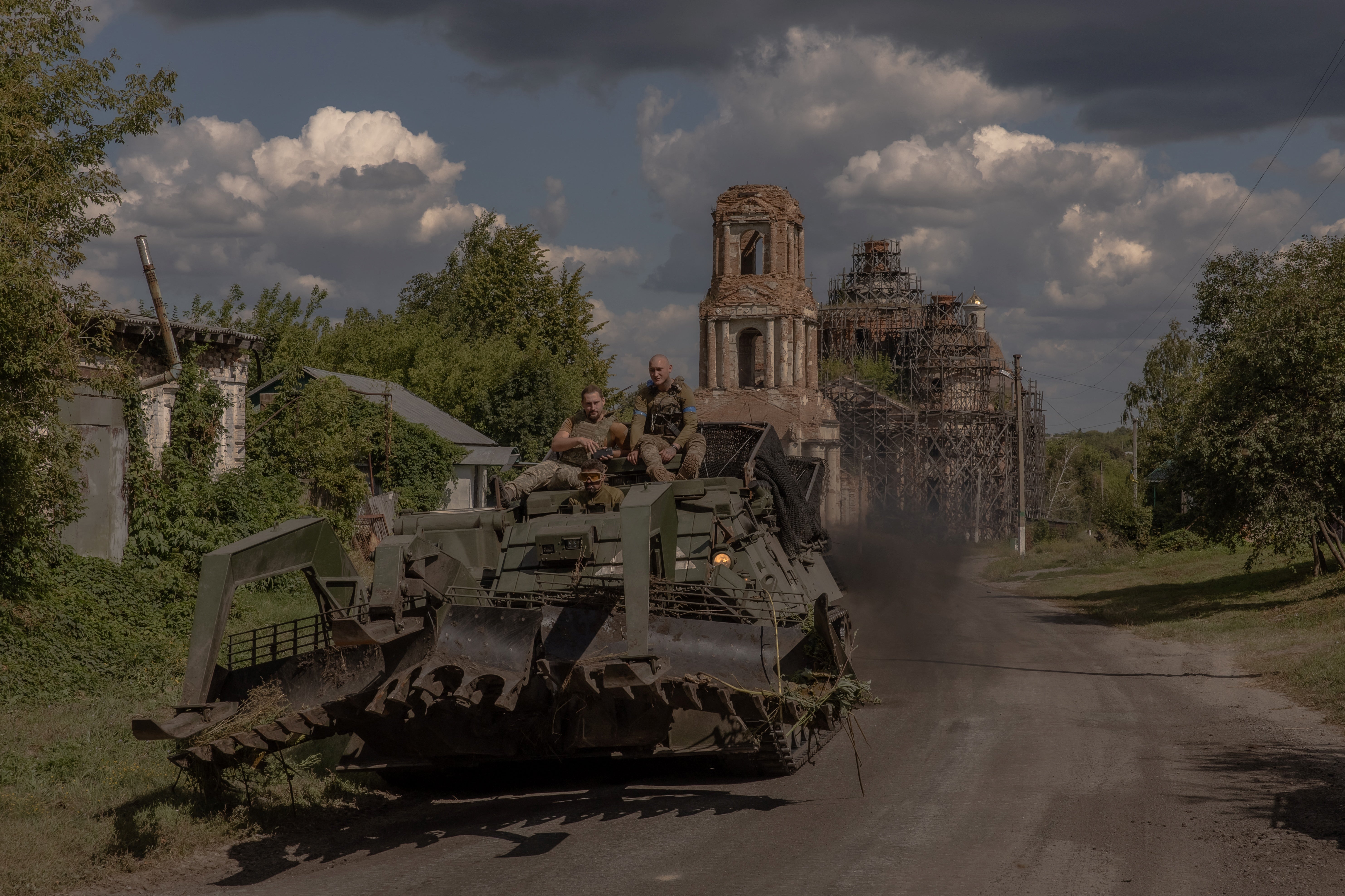 Ukrainian servicemen operate an armoured military vehicle on a road near the border with Russia