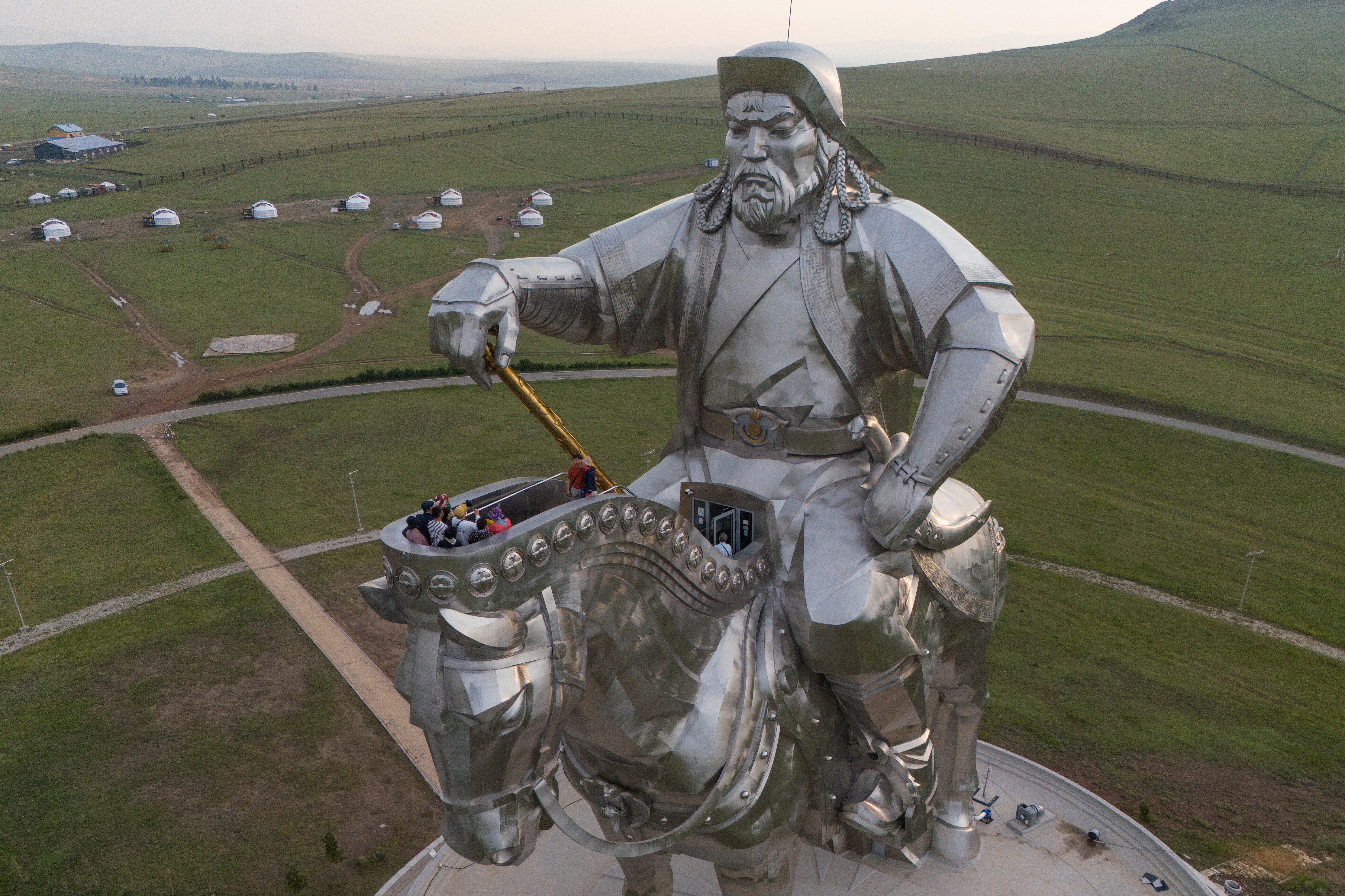 Tourists climb onto the 40-meter- (130-foot-) tall stainless steel statue of Genghis Khan