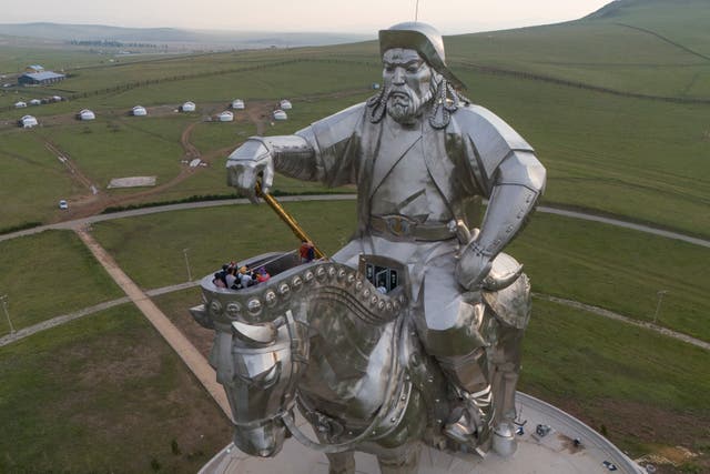 <p>Tourists climb onto the 40-meter- (130-foot-) tall stainless steel statue of Genghis Khan</p>