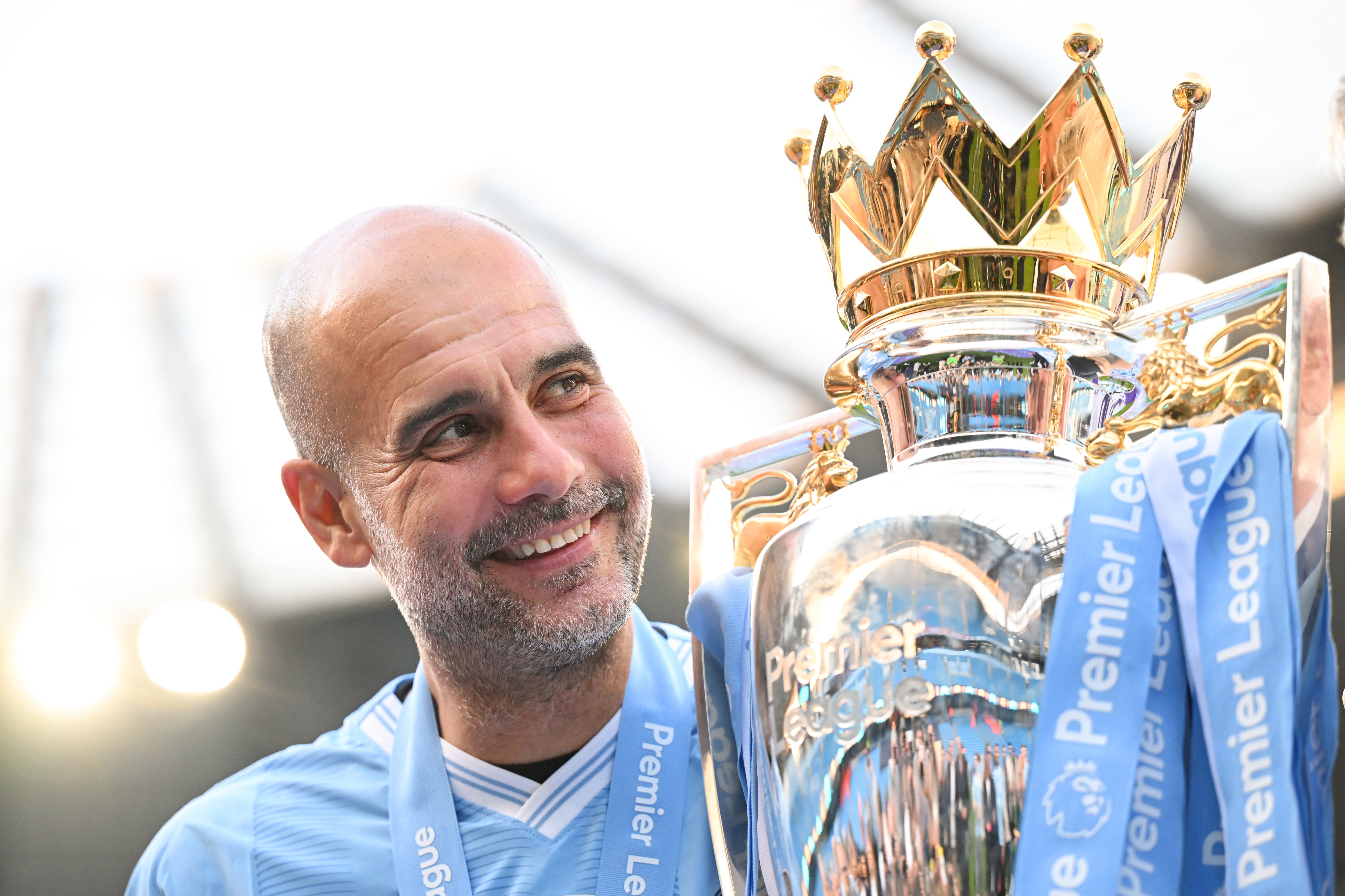 Pep Guardiola, Manager of Manchester City, poses for a photo with the Premier League title trophy