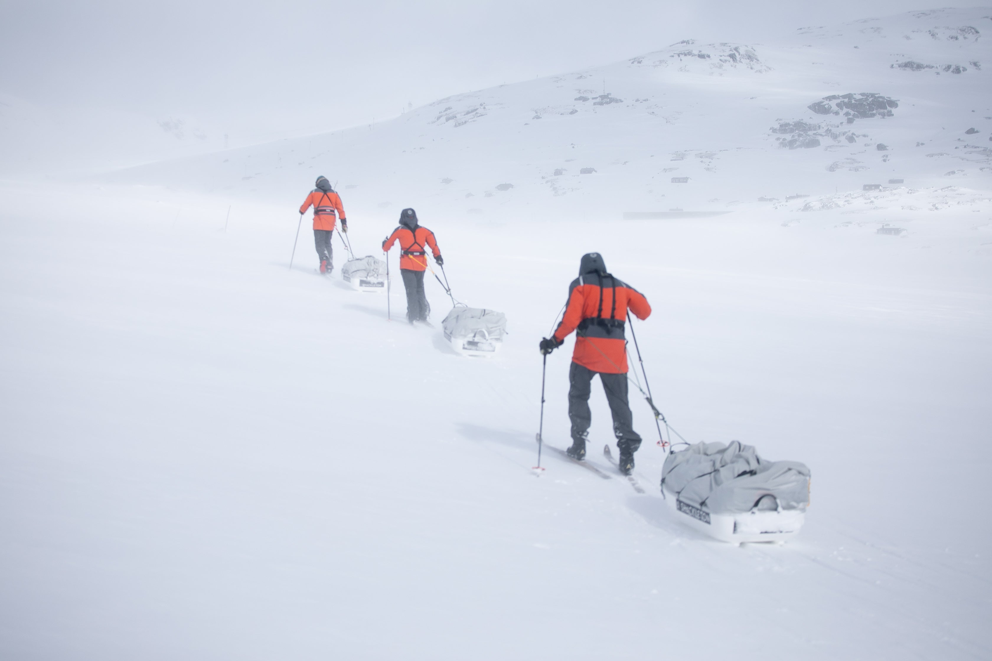 Adventurers drag their pulk sleds through the snow