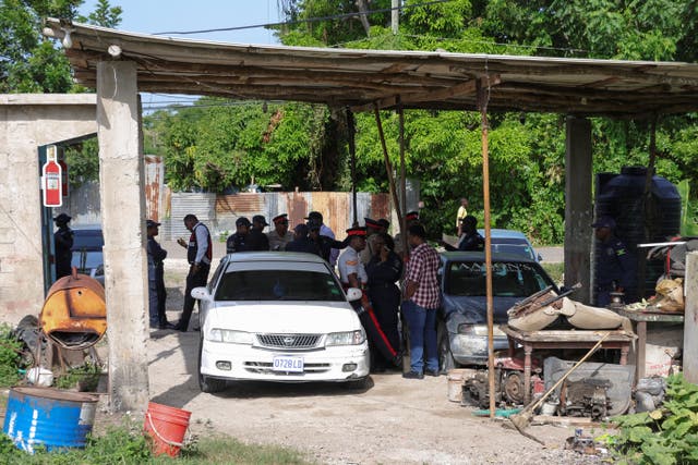 <p>Jamaican officials work at a crime scene in Clarendon, Jamaica on Wednesday after gunmen opened fire at a birthday party, killing seven before an eighth victim died in a separate shooting</p>