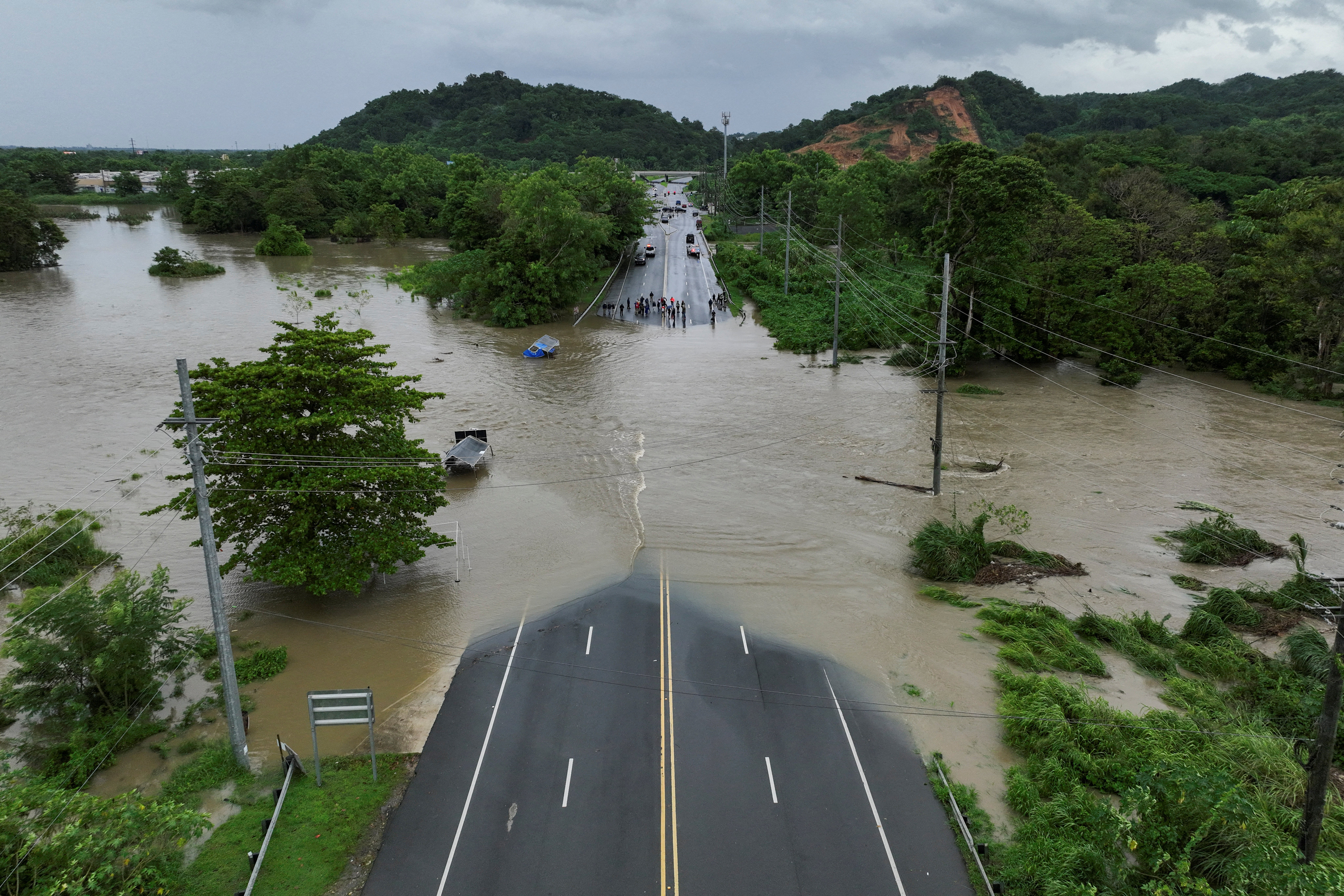 A drone view shows a bridge submerged by the flooded La Plata River in the aftermath of Tropical Storm Ernesto in Toa Baja, Puerto Rico