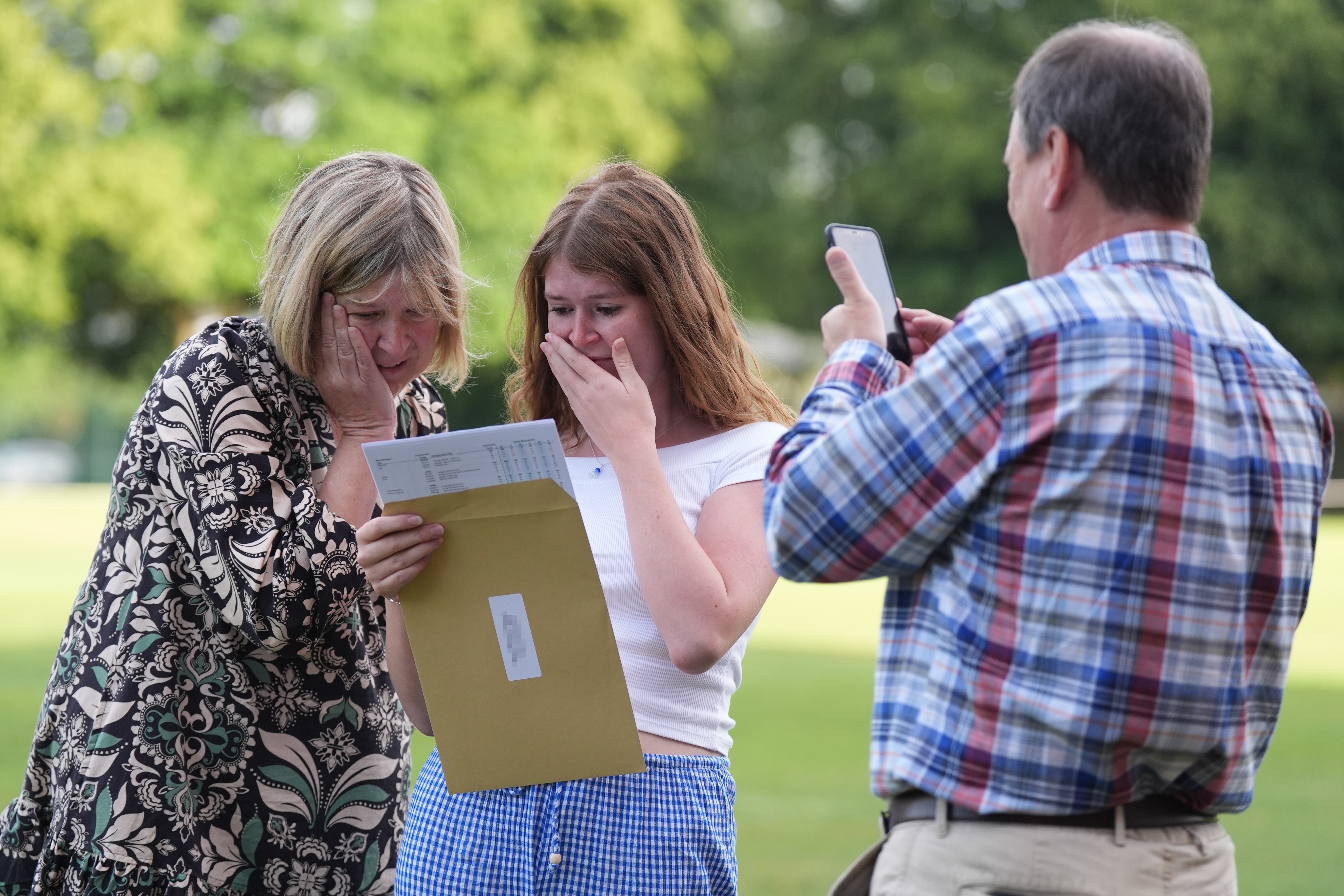 LABEL PIXELATED BY PA PICTURE DESK Hannah Greenwood reacts with her parents (names not given) after receiving good A-level results at Solihull School in the West Midlands. Picture date: Thursday August 15, 2024.