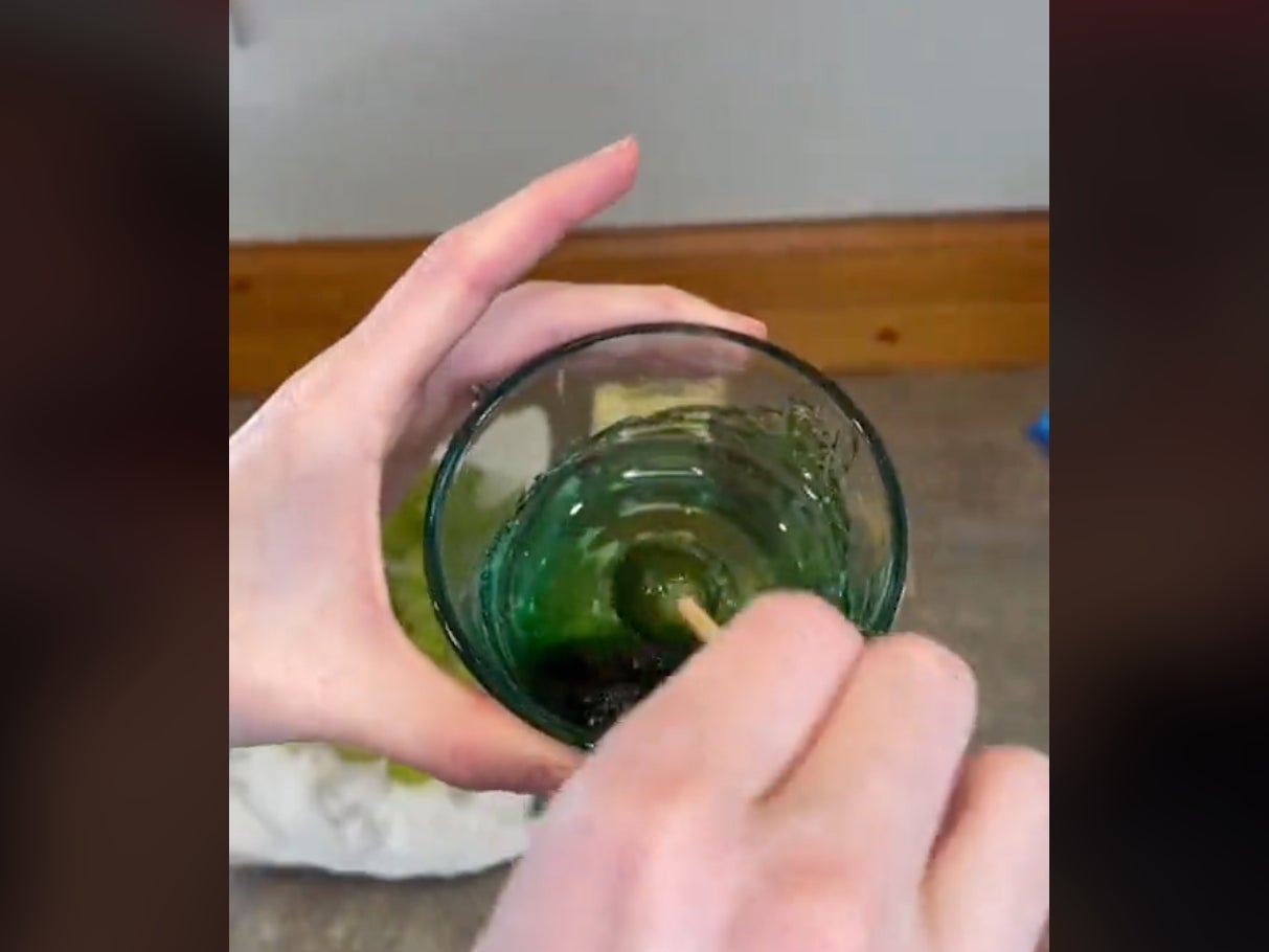 TikTok user @its.just.leah swabs a grape on a skewer into a glass of molten candy while making viral “candy grapes” for a video. The user — and several others who have attempted the recipe — have suffered burns while making the sweets caused by the high temperature of the molten candy