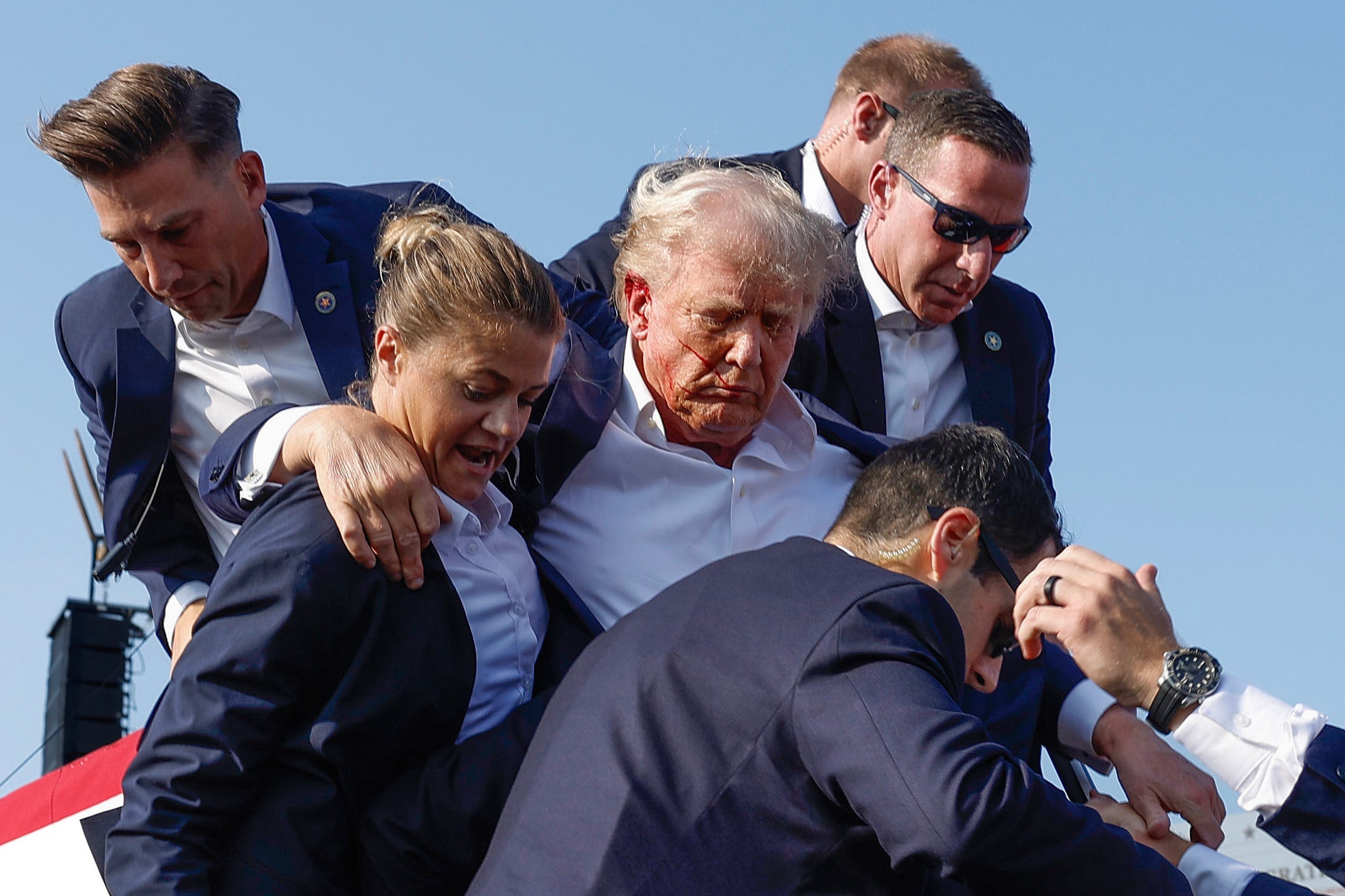 Former President Donald Trump is rushed offstage by U.S. Secret Service agents after being grazed by a bullet during a rally on July 13, in Butler, Pennsylvania. Now, according to a report, the Secret Service wants to put bulletproof glass around Trump’s podium at future outdoor rallies.