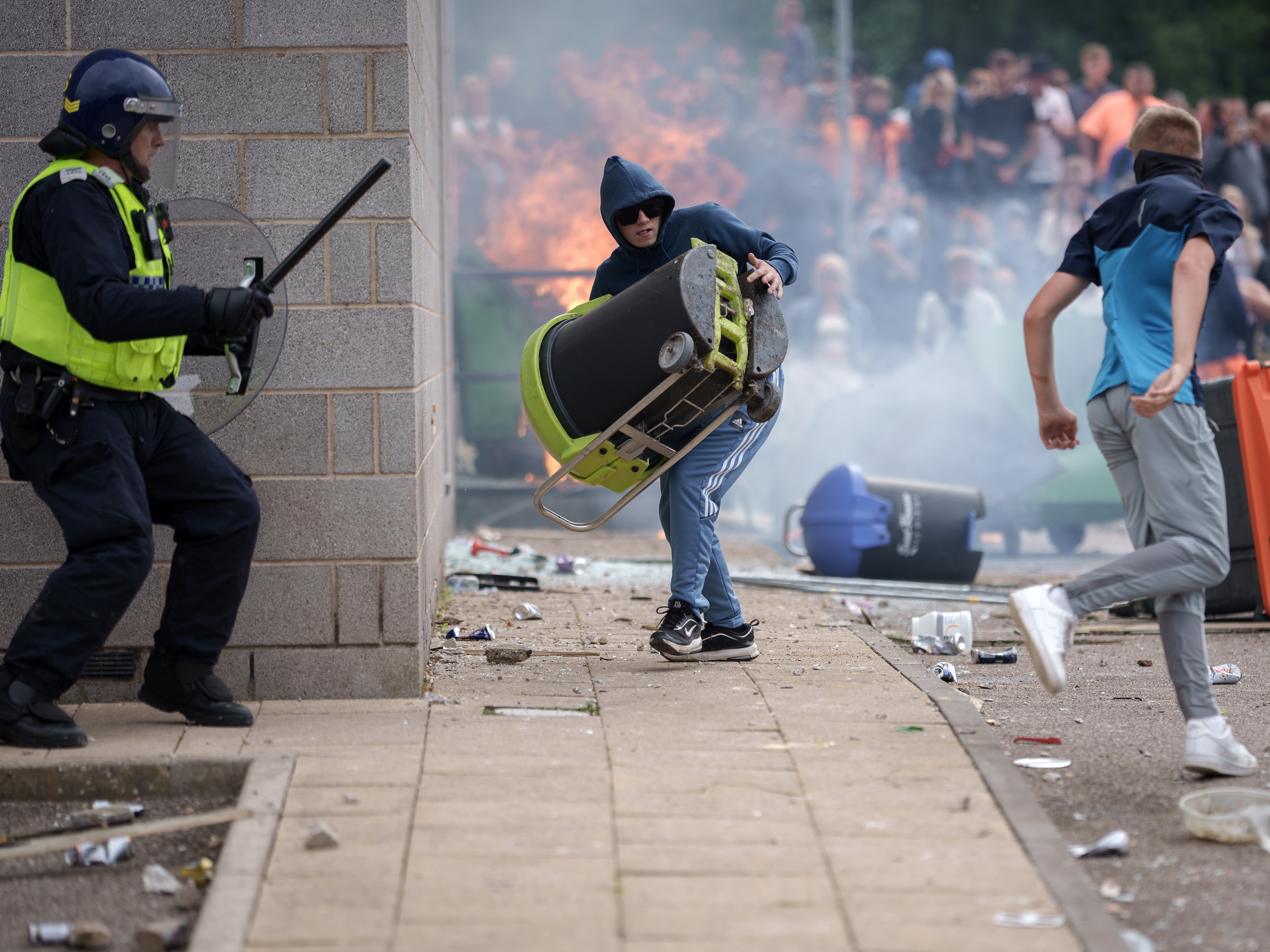 Riot police push back anti-immigration protesters outside the Holiday Inn Express hotel in Rotherham during the riots