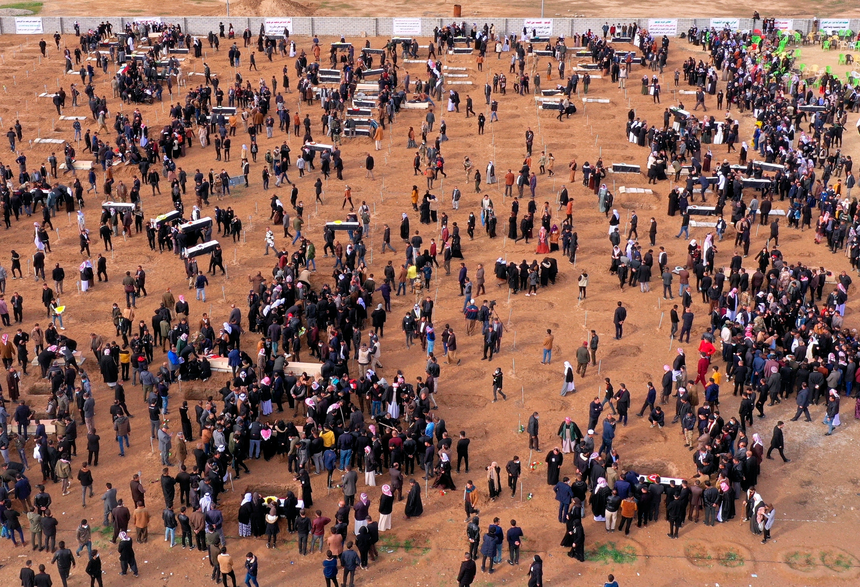 An aerial view of mourners preparing to bury the remains of Yazidi victims in a cemetery in Sinjar, Iraq, Saturday, 6 Feb 2021