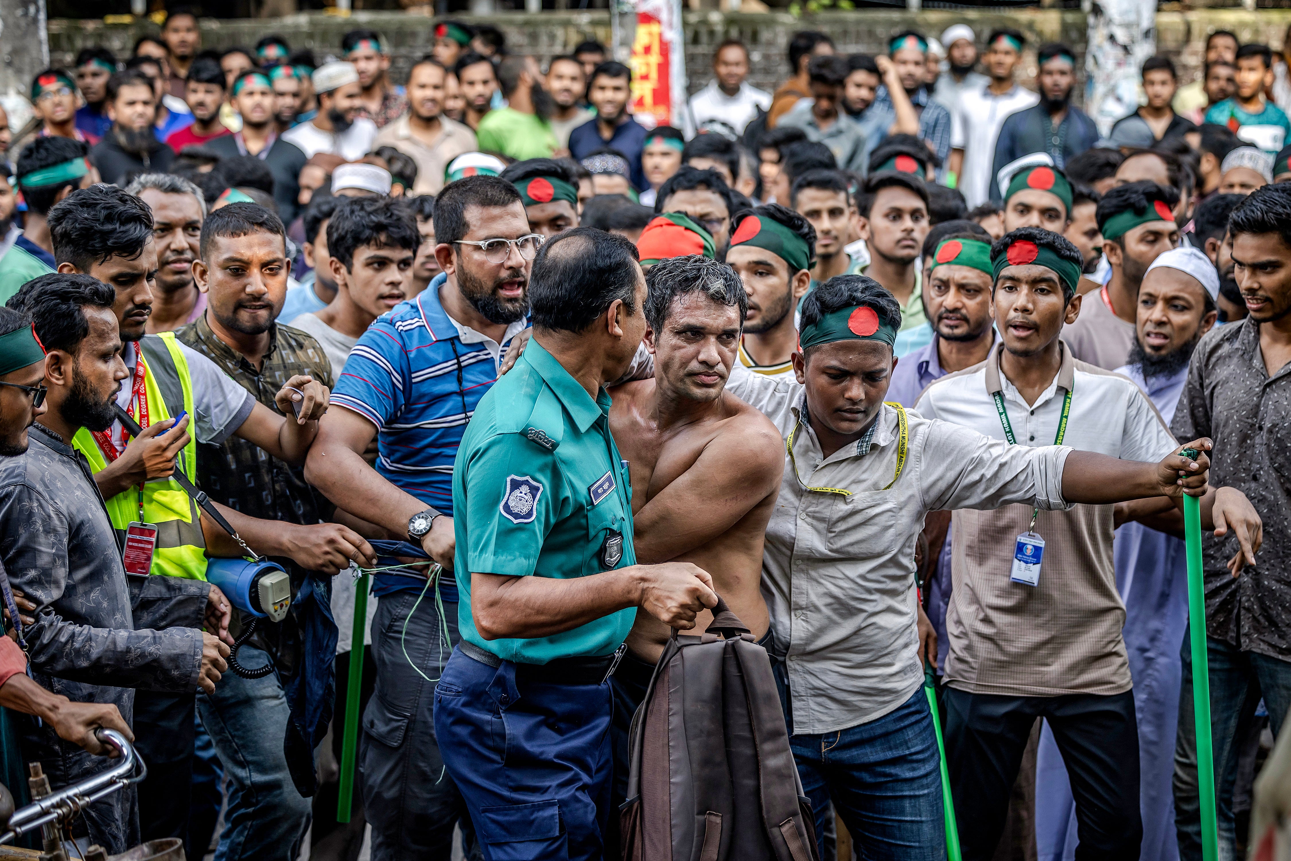 Protesters surround a suspected sympathiser of ousted premier Sheikh Hasina near the house of her father Sheikh Mujibur Rahman in Dhaka